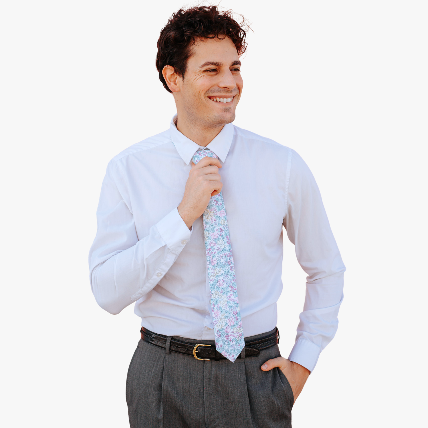 A man in dress clothes wearing a floral tie with pastel pink flowers, yellow petals, blossoms and light blue leaves.