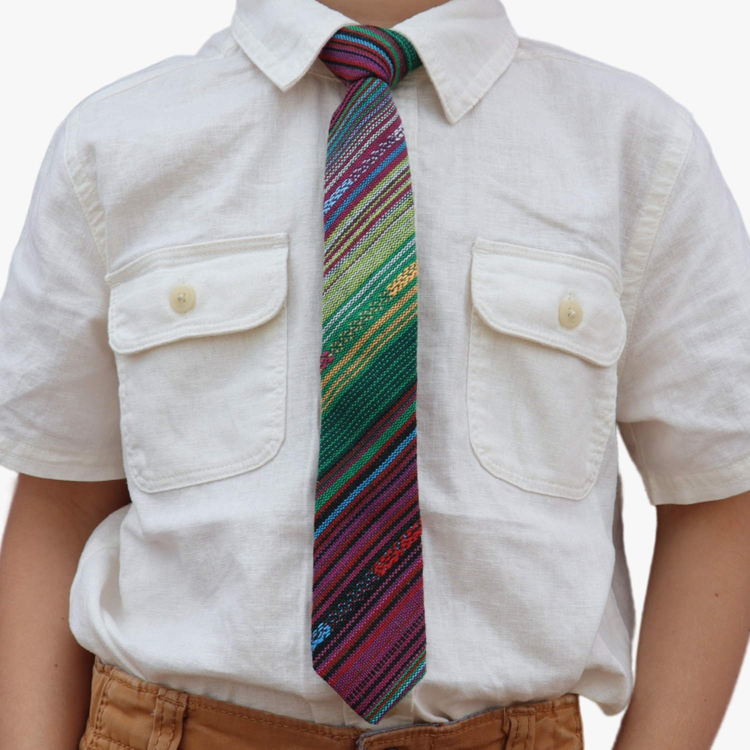 The torso of a boy wearing a striped kids tie with green stripes, purple lines, yellow bars, blue designs and Mexican styles.