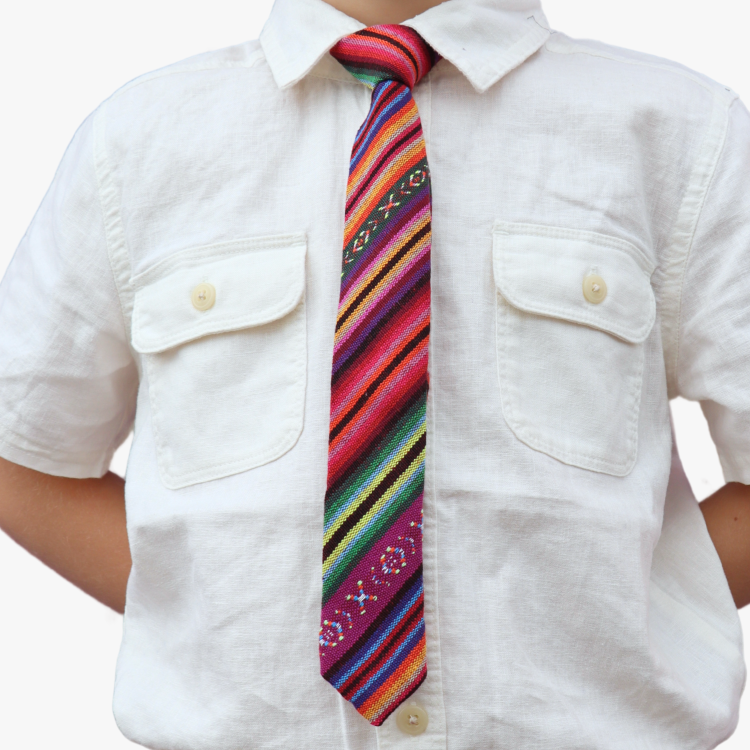 The torso of a boy wearing a striped kids tie with purple stripes, green and yellow lines, orange and red bars.