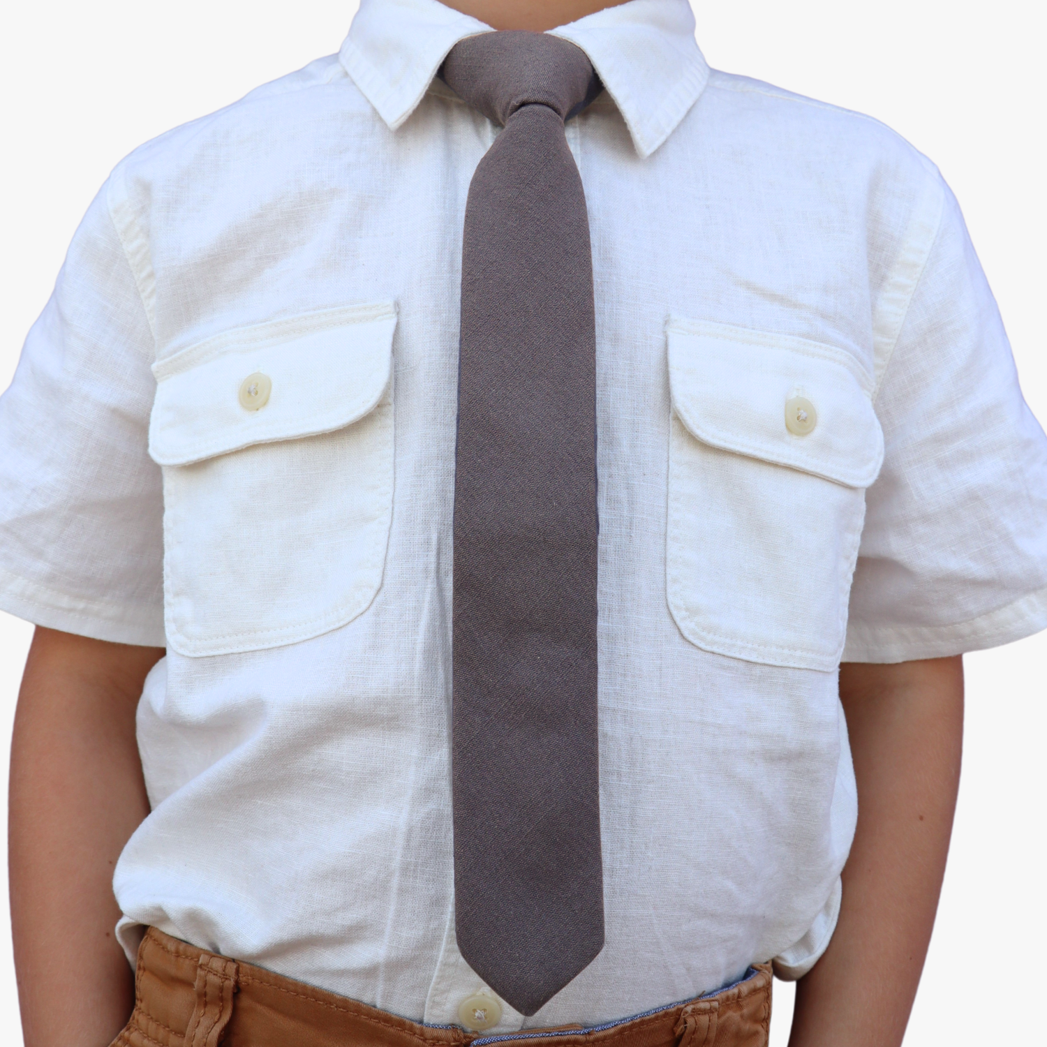 The torso of a boy wearing a solid kids tie with plain dark gray/grey color.