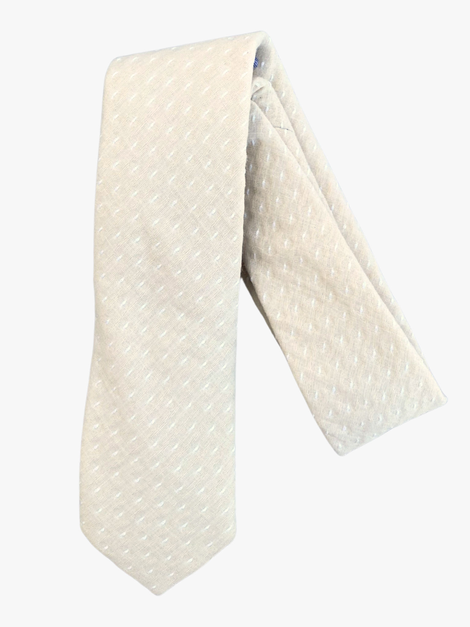 A folded polka dot adult men's necktie with a light beige tan fabric and a simple repeating pattern of white dots or spots.
