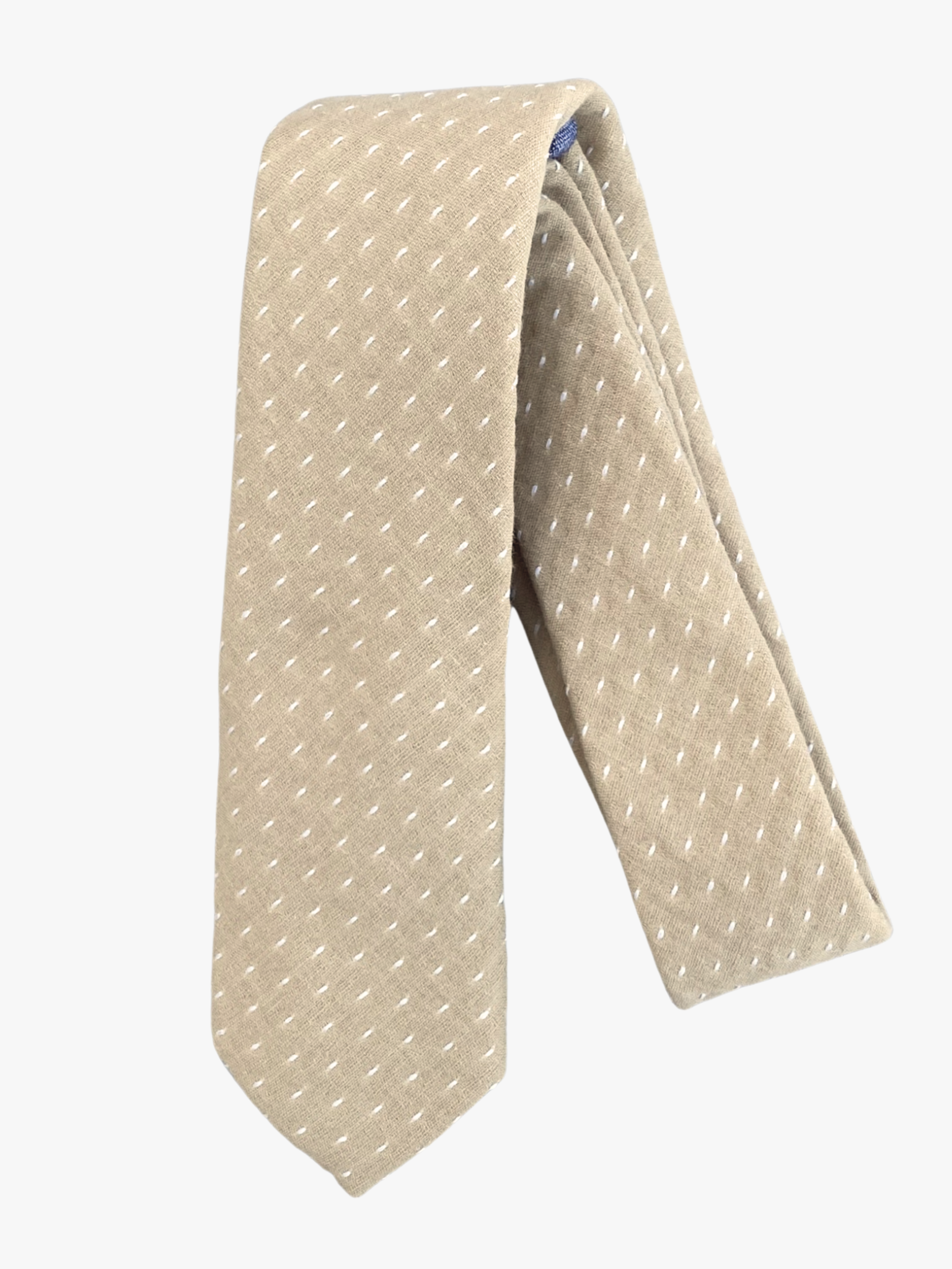 A folded polka dot adult men's necktie with a sandy tan fabric and a simple repeating pattern of white dots or spots.