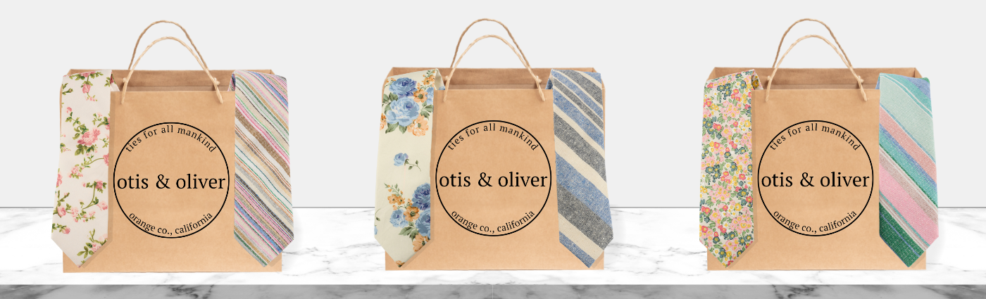 3 brown paper shopping bags that feature the Otis &amp; Oliver logo and are filled with pastel striped and floral ties.