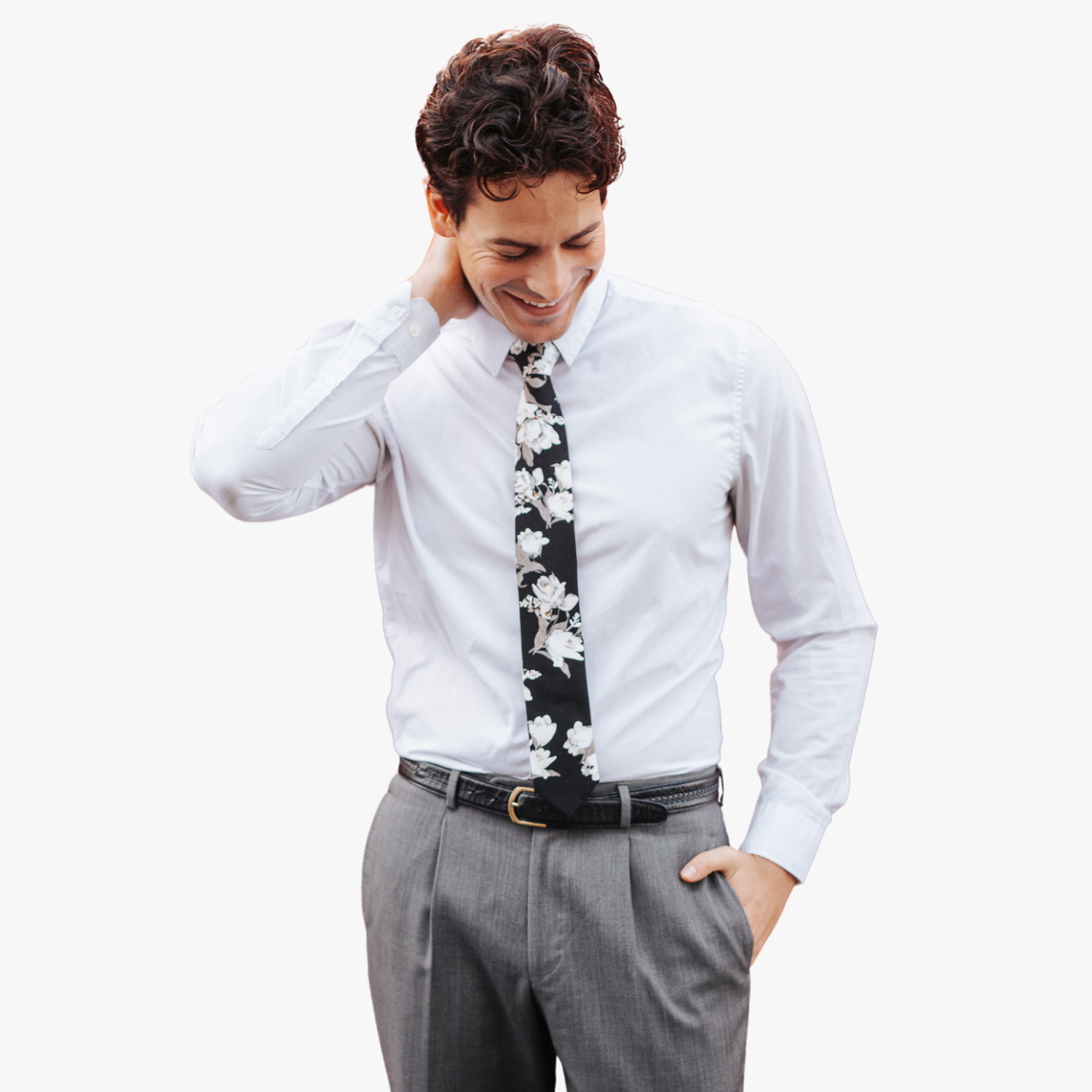 A man in dress clothes wearing a floral tie with ghostly white flowers, pale petals, rose blossoms and gray leaves.