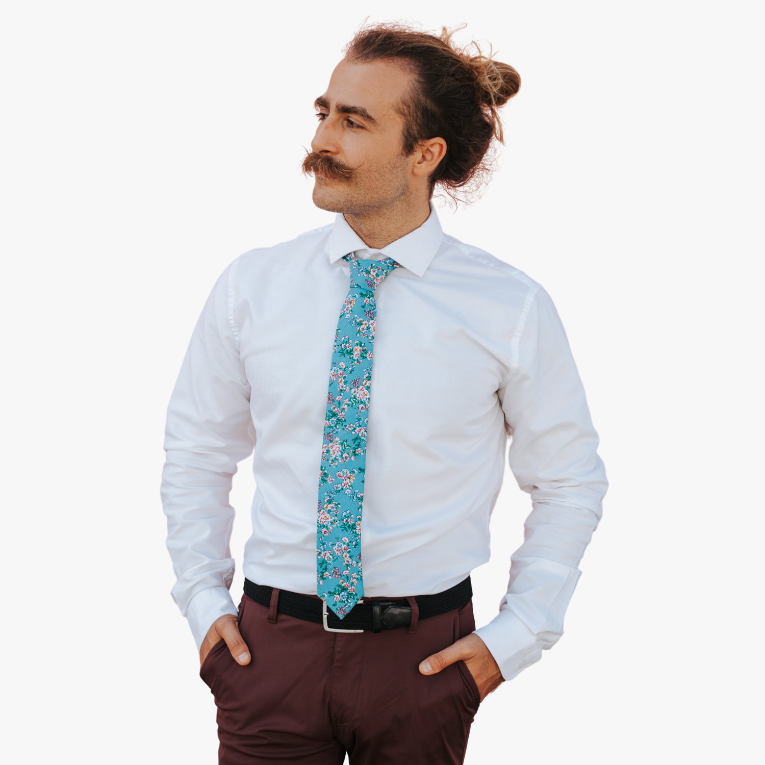 A man in dress clothes wearing a floral tie with watercolor turqouise flowers, pink and yellow blossoms, and green leaves.