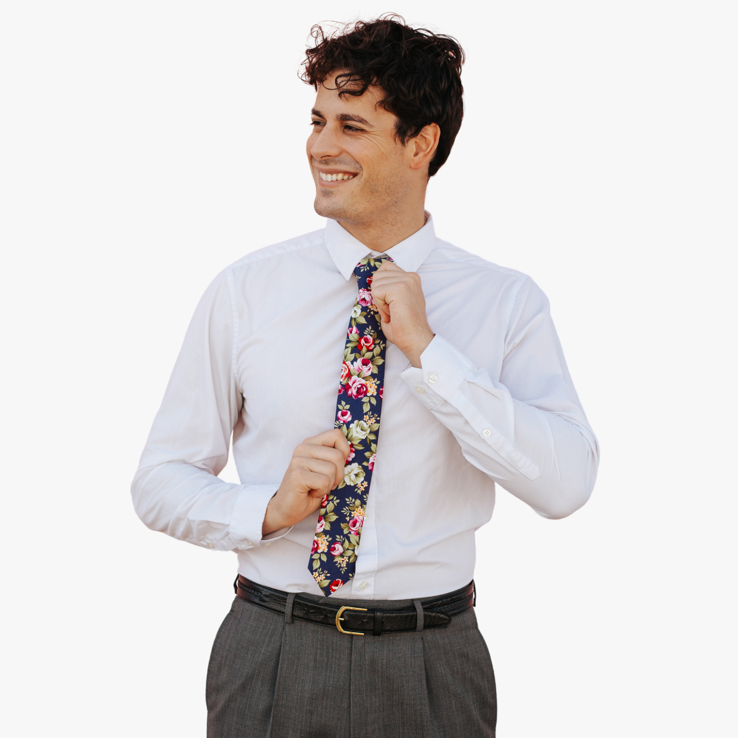 A man in dress clothes wearing a floral tie with pink rose flowers, red petals, yellow blossoms and green leaves.