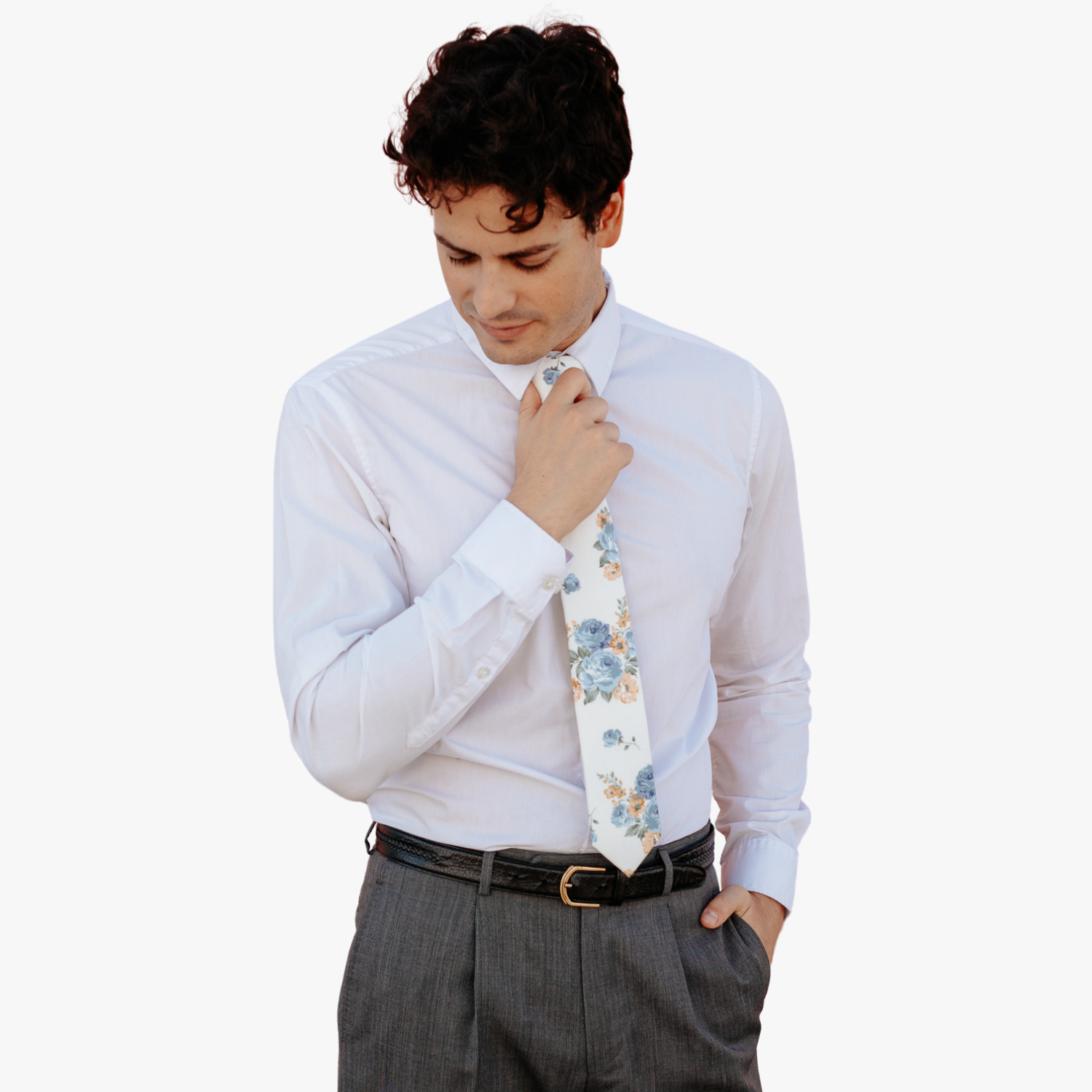 A man in dress clothes wearing a floral tie with  dusty blue rose flowers, deep yellow petals, and light green leaves.