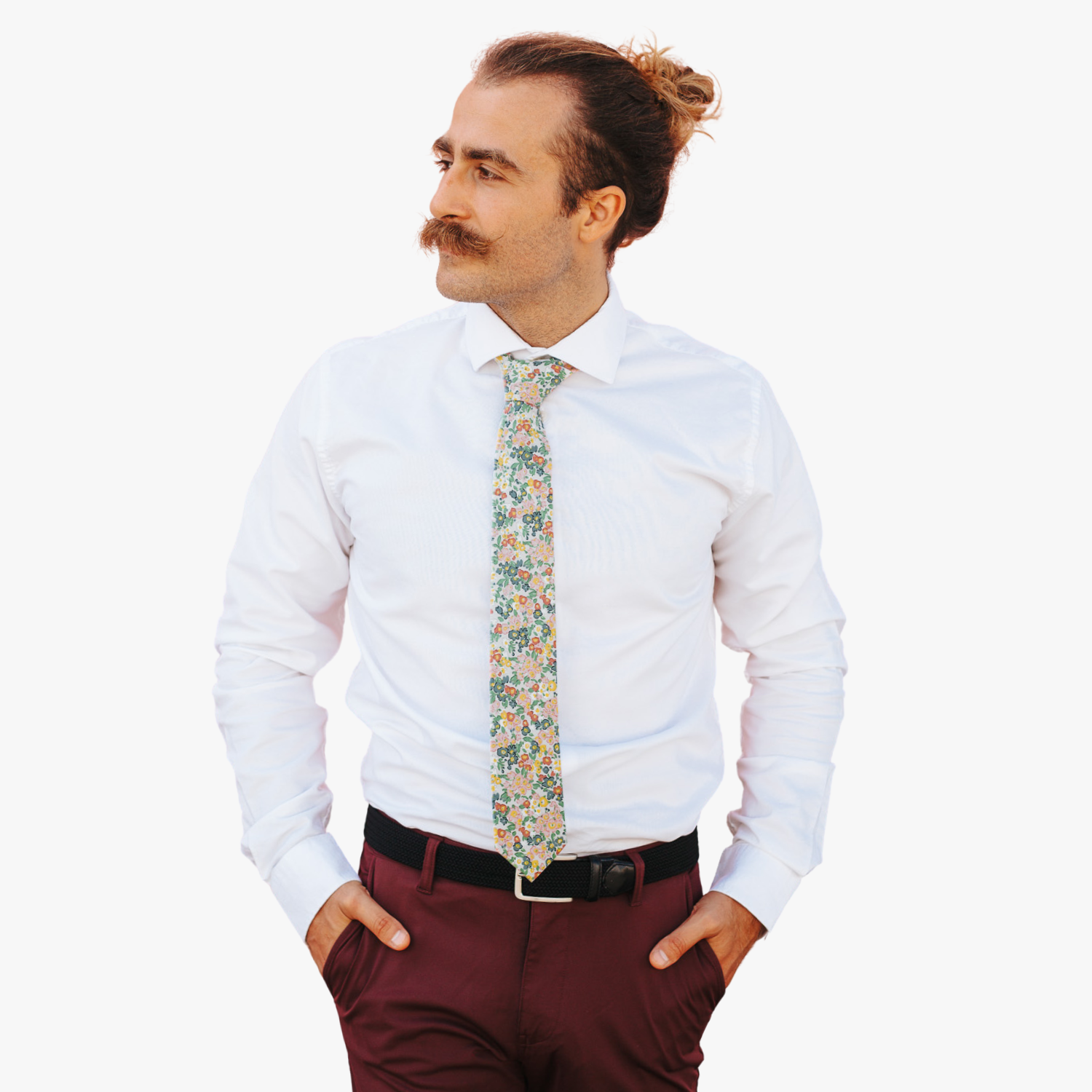 A man in dress clothes wearing a floral tie with small pink flowers, teal petals, yellow blossoms and green leaves.
