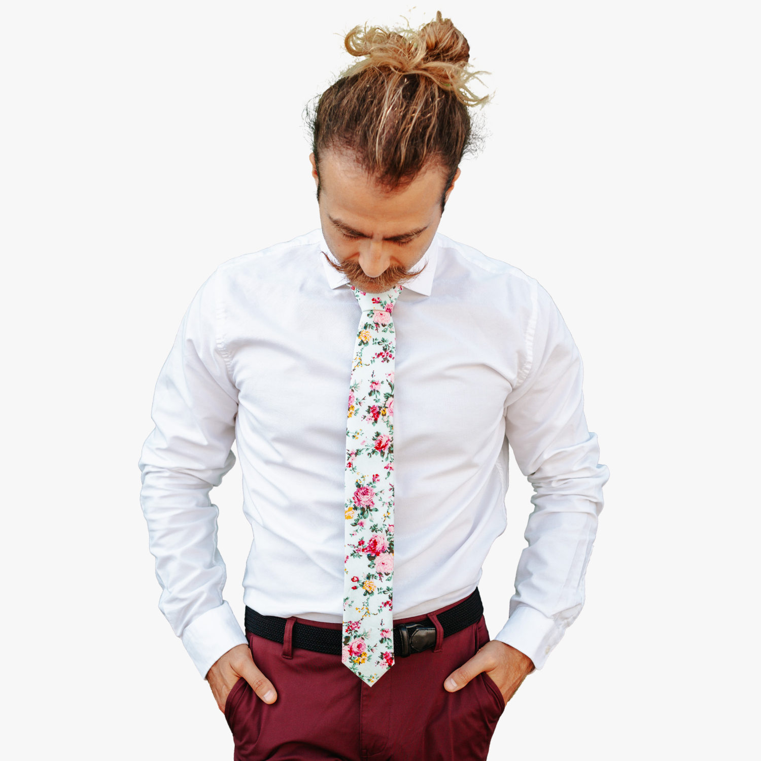 A man in dress clothes wearing a floral tie with pink rose flowers, yellow petals, dark blossoms and green leaves.