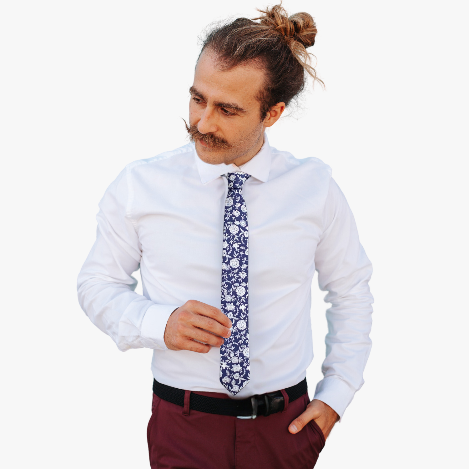 A man wearing a floral tie with navy blue fabric, and white flowers and vines remenisicent of fine china or talevera pottery.