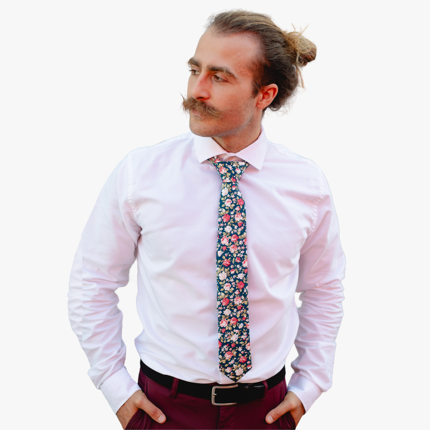 A man in dress clothes wearing a floral tie with red rose flowers, pink petals, light blossoms and pale green leaves.