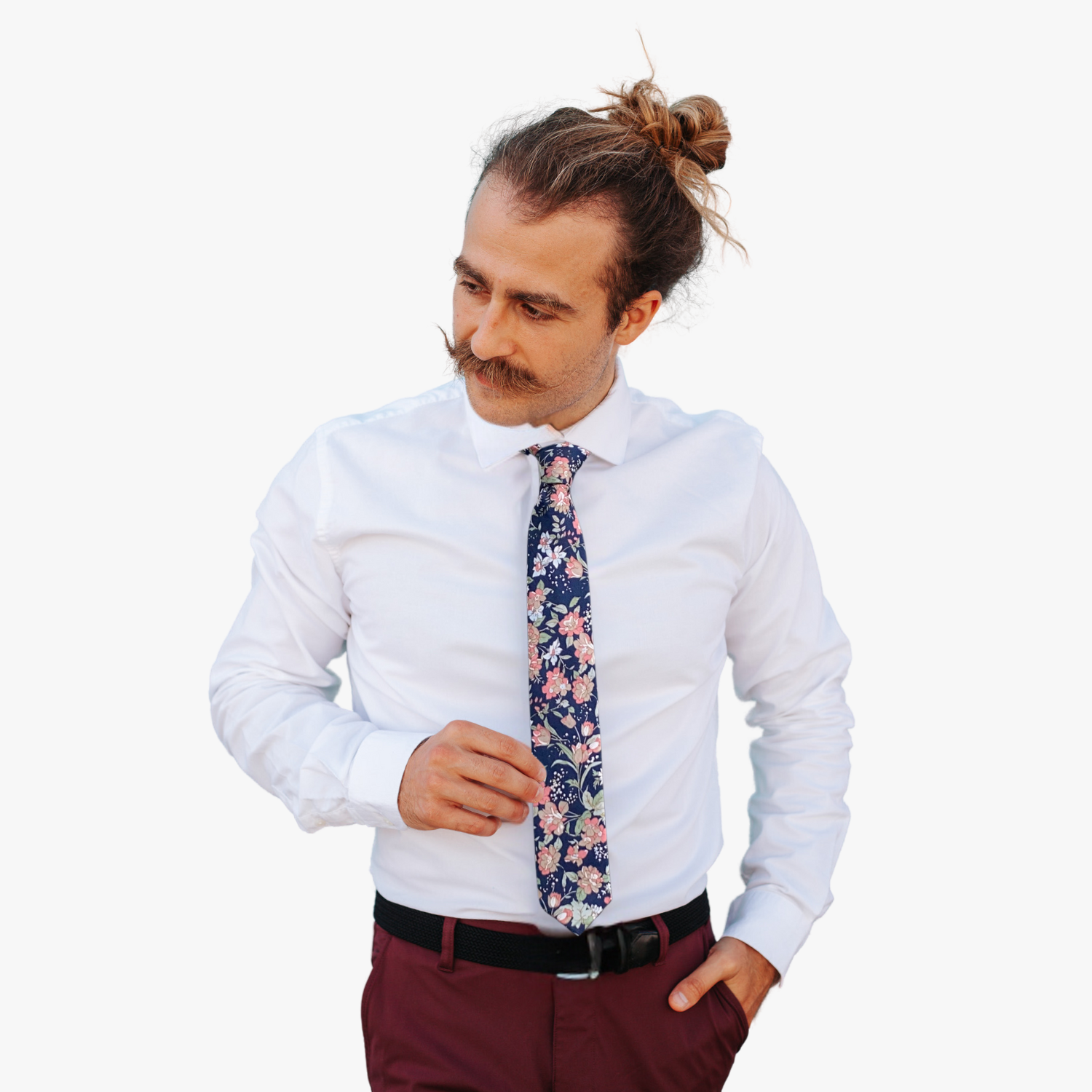 A man wearing a floral tie with deep navy blue fabric, pink and brown flowers, pastel sage green leaves, and white flowers.