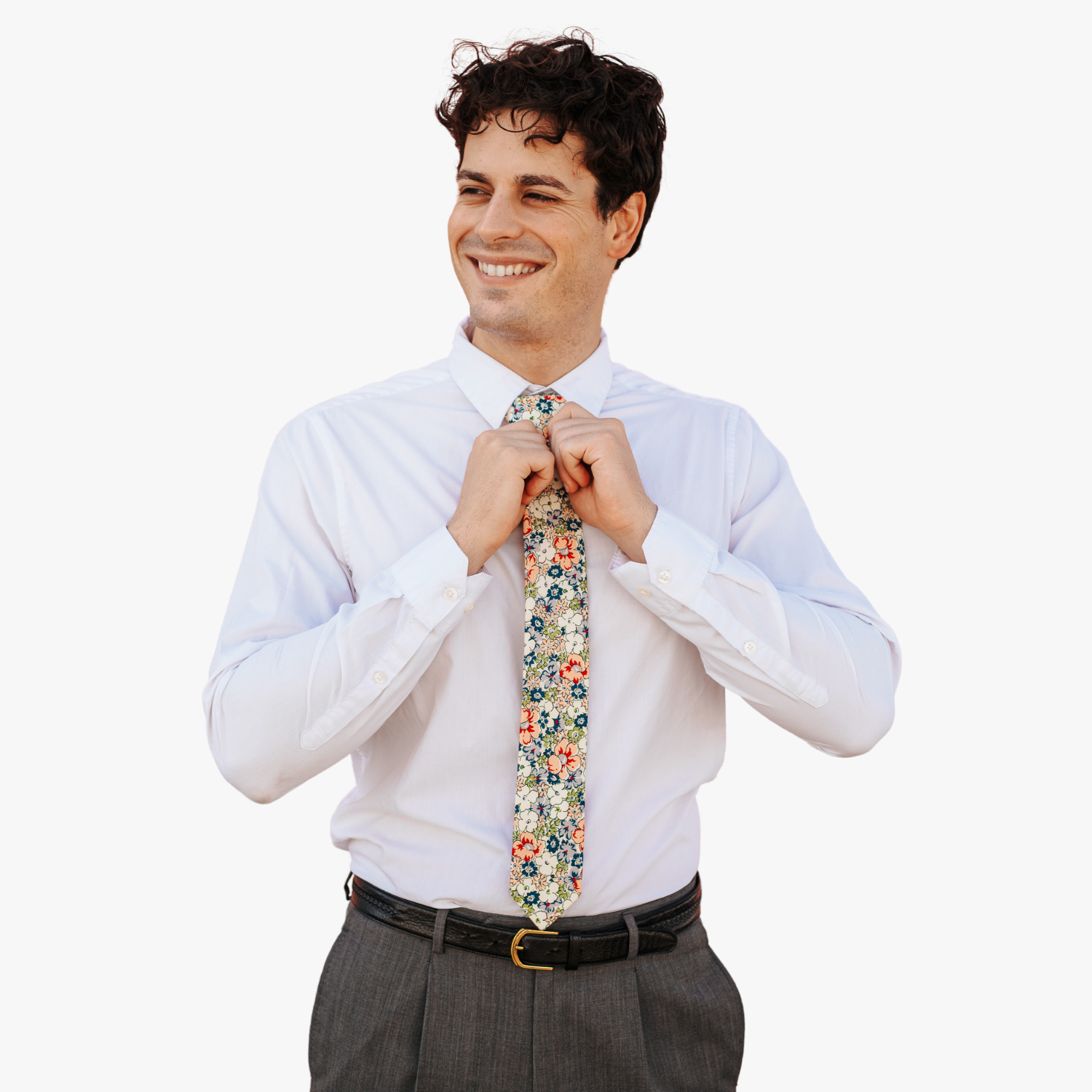A man in dress clothes wearing a floral tie with blue flowers, white petals, and peach or salmon blossoms and green leaves.