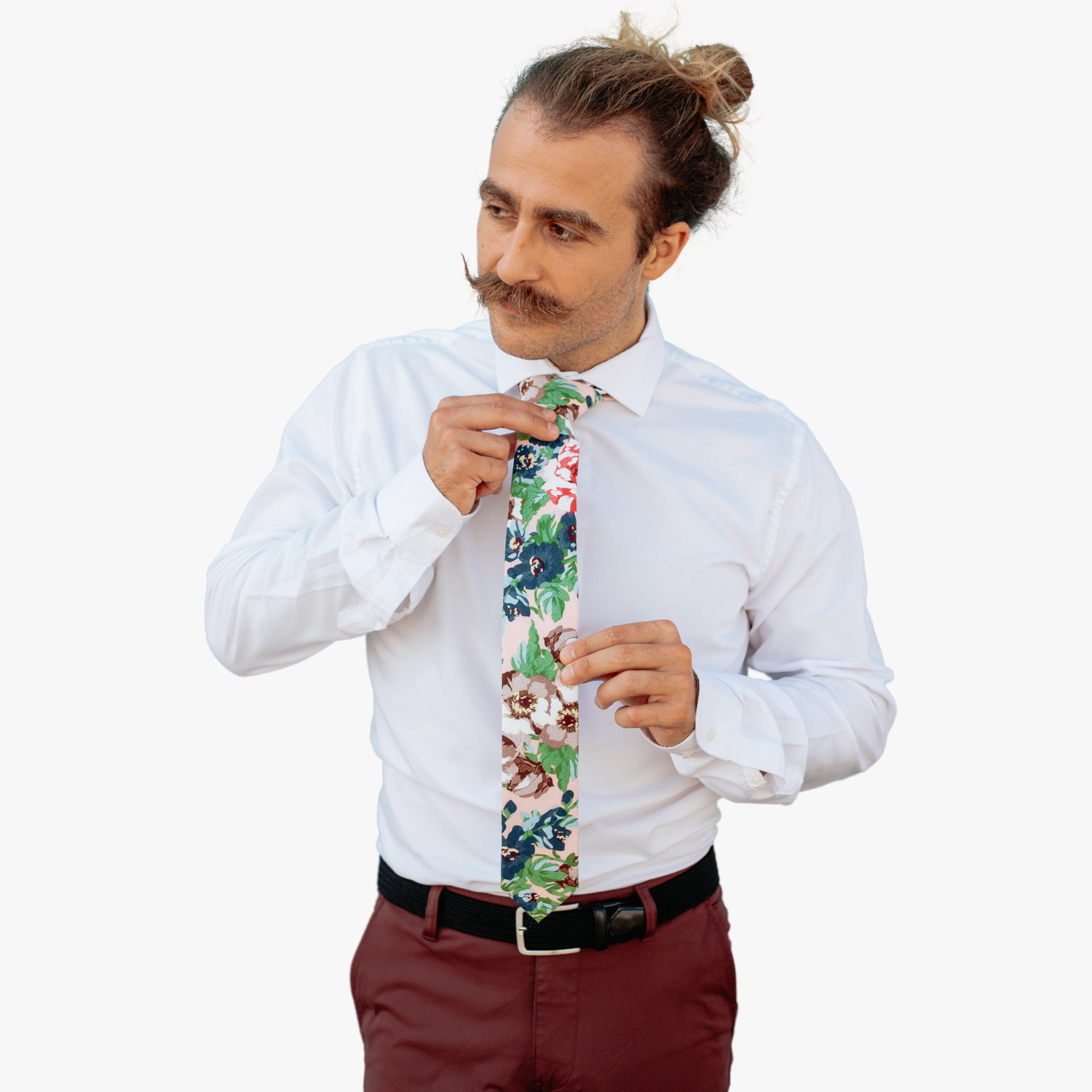 A man in dress clothes wearing a floral tie with dark blue flowers, brown petals, and light green water leaves.
