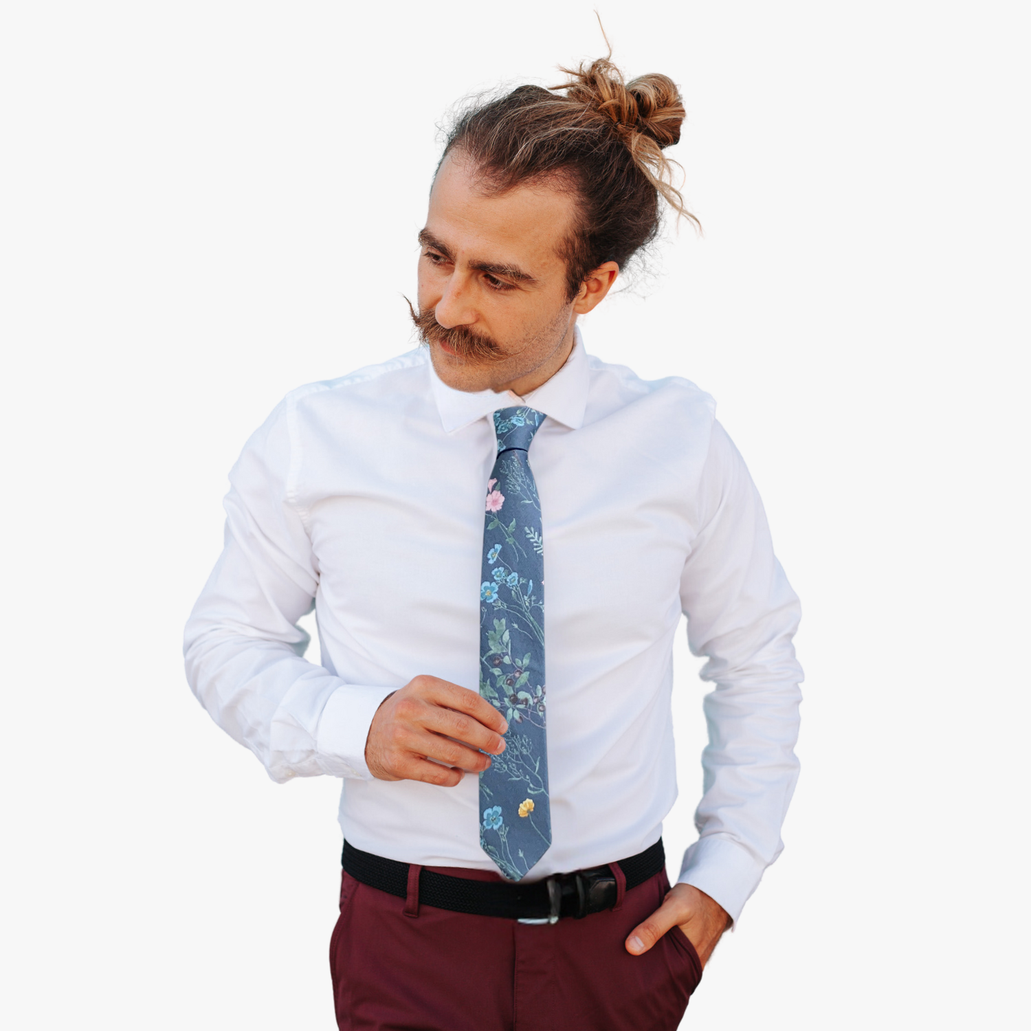 A man wearing a floral tie with gray fabric with subtle turquoise, teal, pink, and yellow flowers with long green stems.
