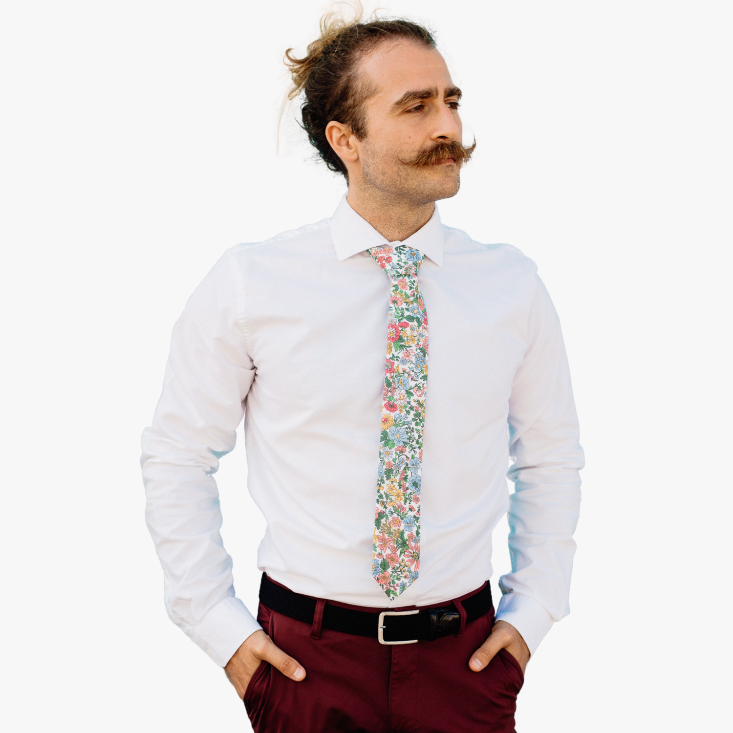 A man in dress clothes wearing a floral tie with pink wildflowers, blue petals, yellow blossoms, and green leaves.