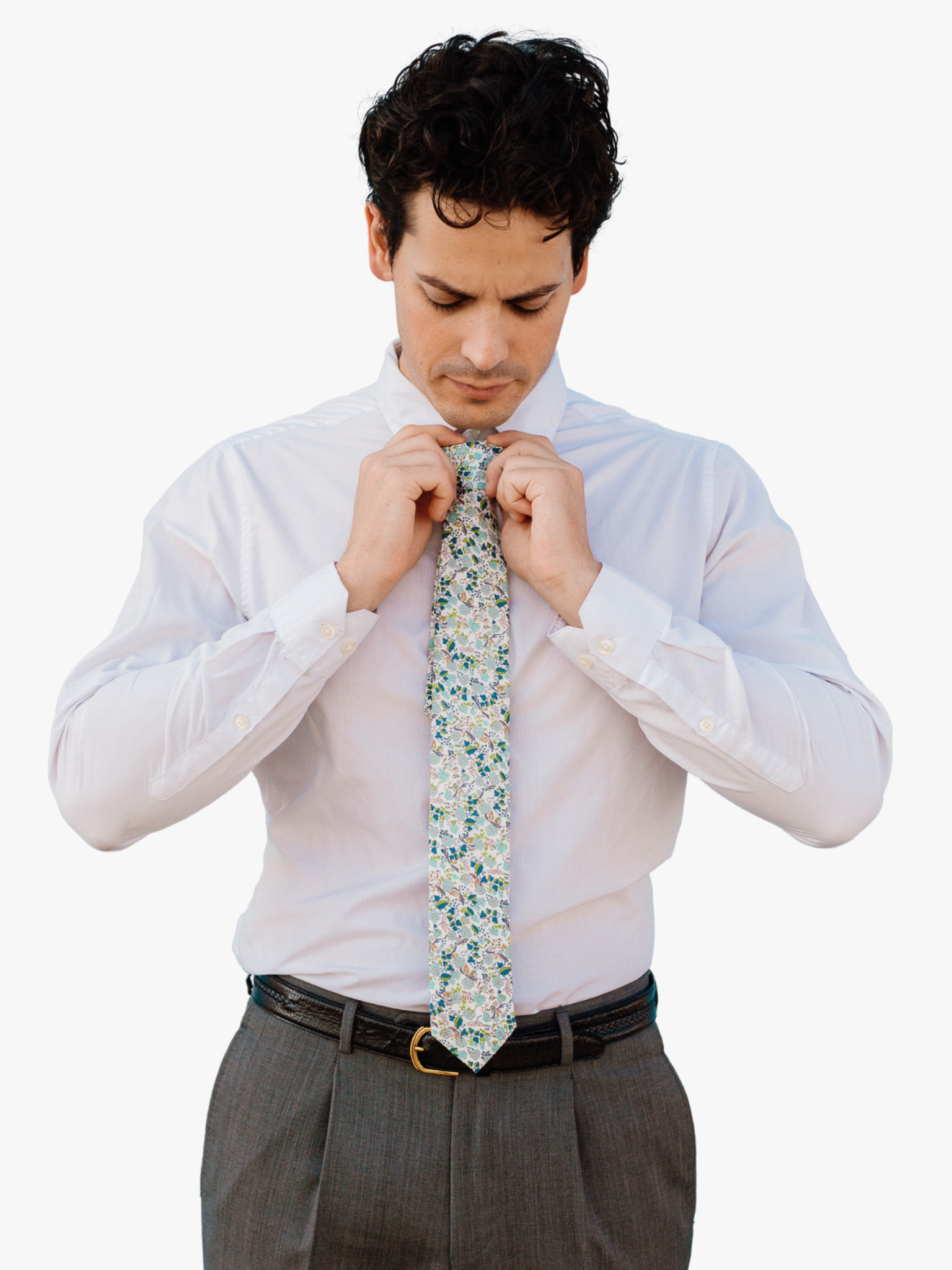 A man wearing a floral tie with  dusty blue flowers, pink centers, turquoise blossoms and bluish green leaves.