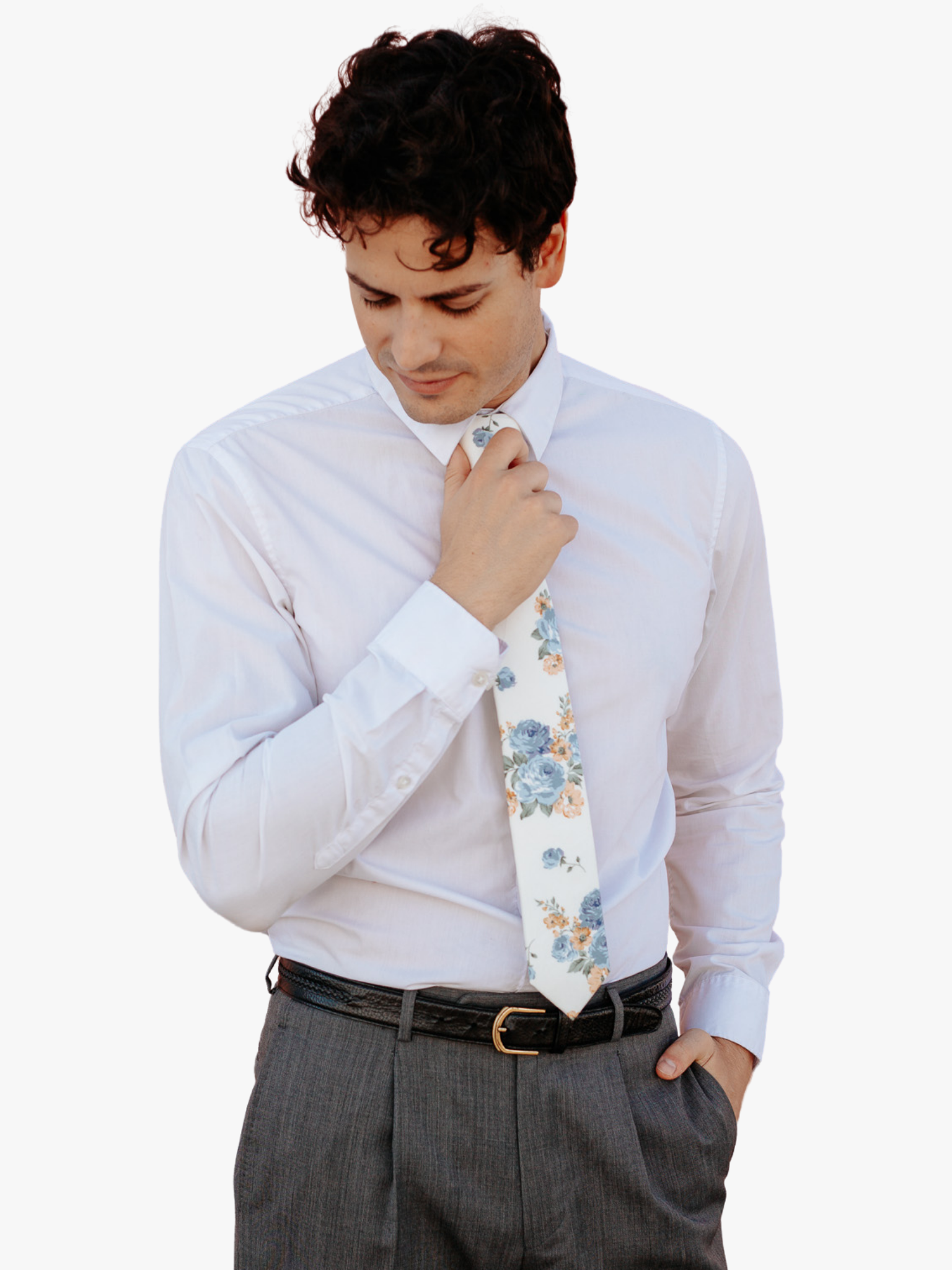 A man in dress clothes wearing a floral tie with  dusty blue rose flowers, deep yellow petals, and light green leaves.