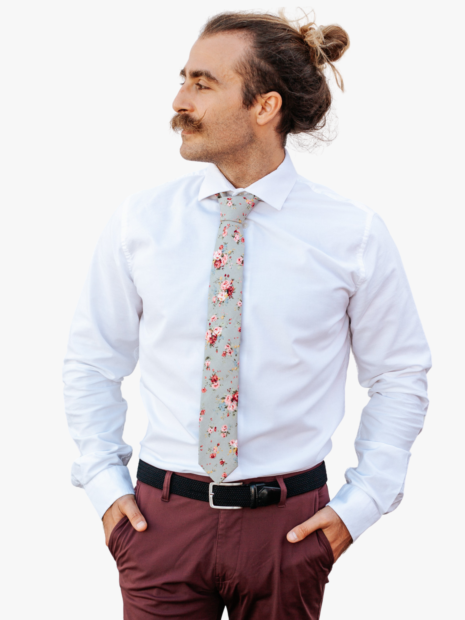 A man in dress clothes wearing a floral tie with red roses flowers, yellow and pink blossoms and green leaves designs on it.