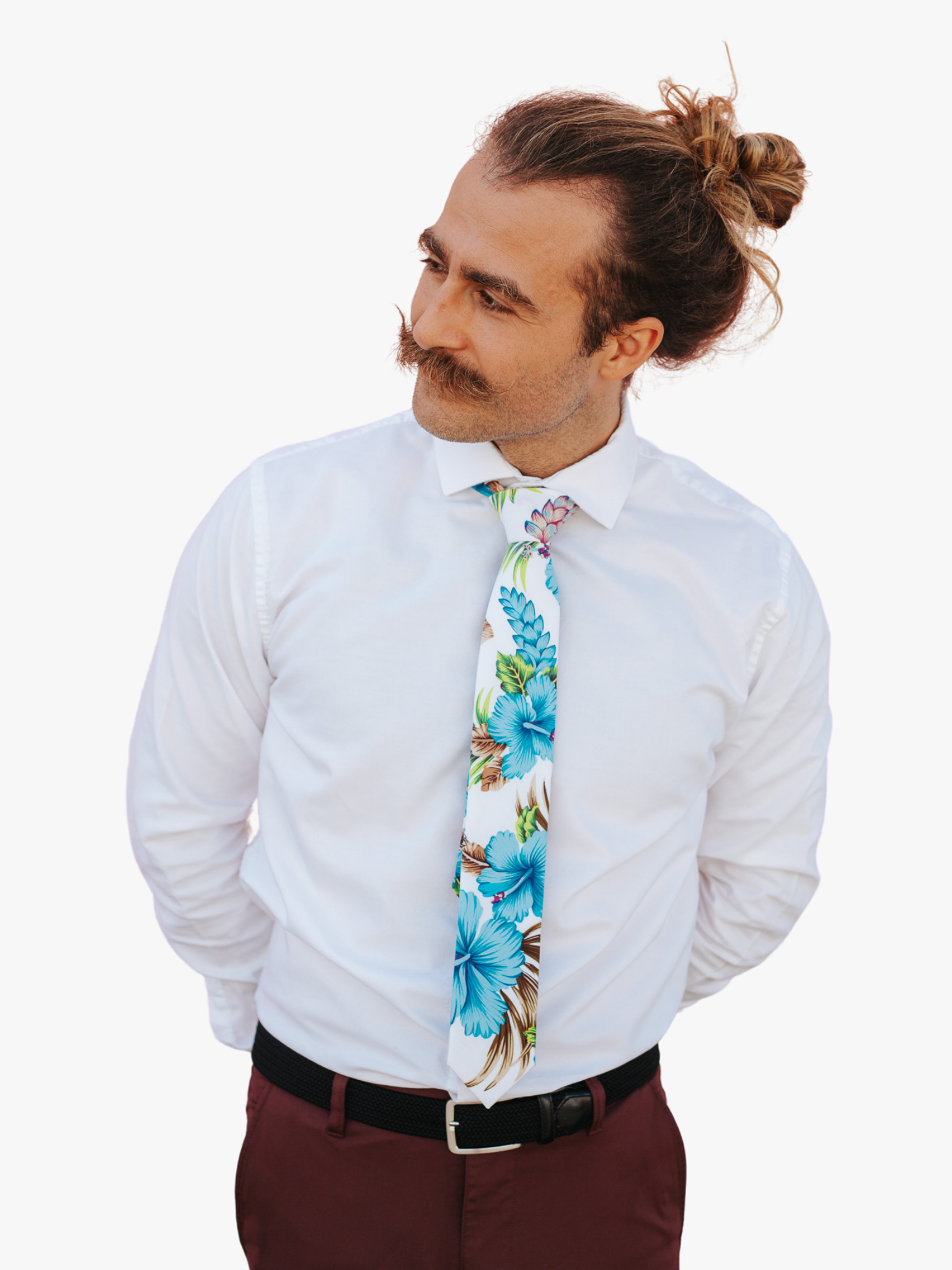 A man wearing a floral tie with Large dusty blue beach flowers, hibiscus petals, spots of pink, and brown leaves.