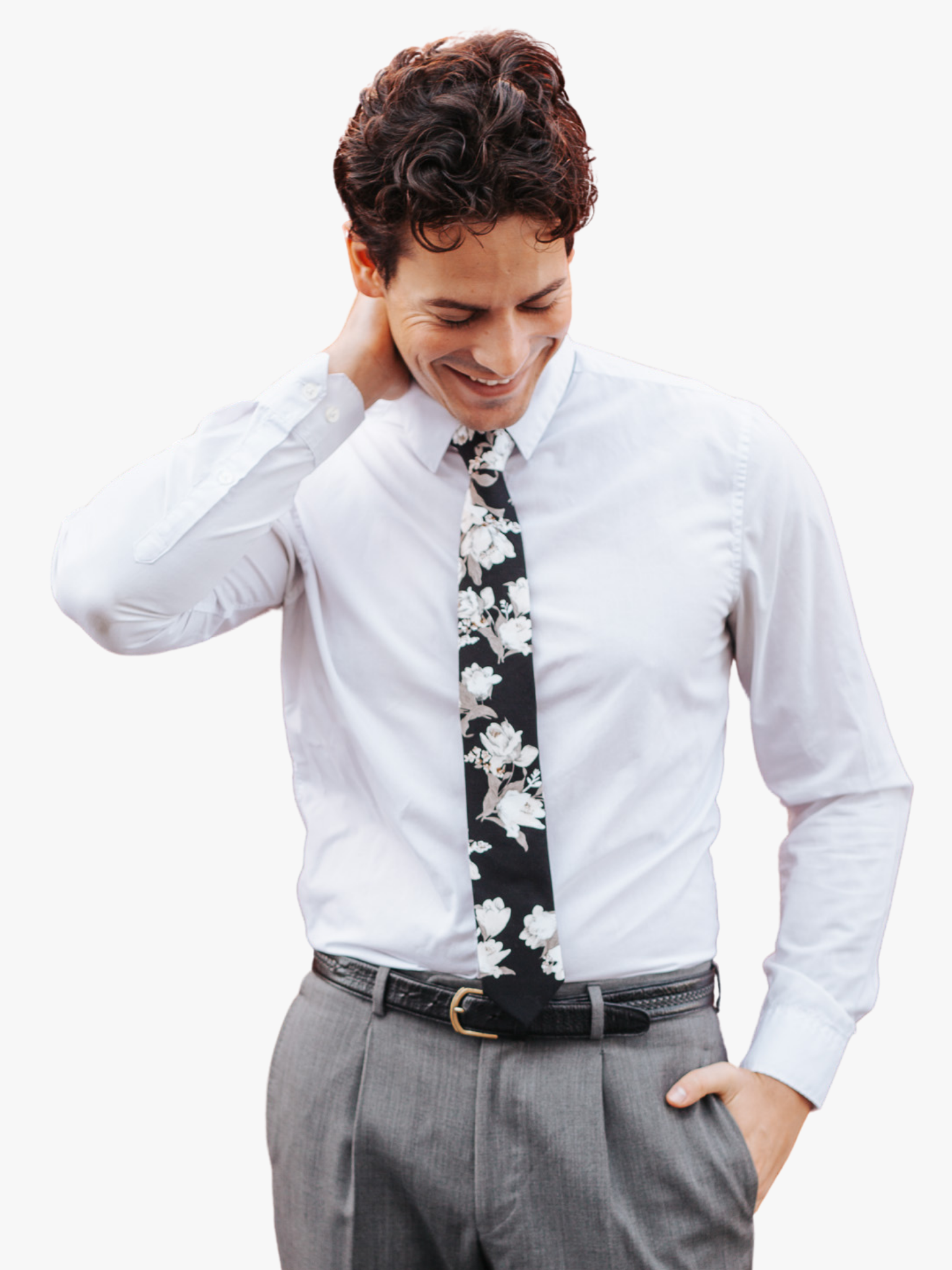 A man in dress clothes wearing a floral tie with ghostly white flowers, pale petals, rose blossoms and gray leaves.