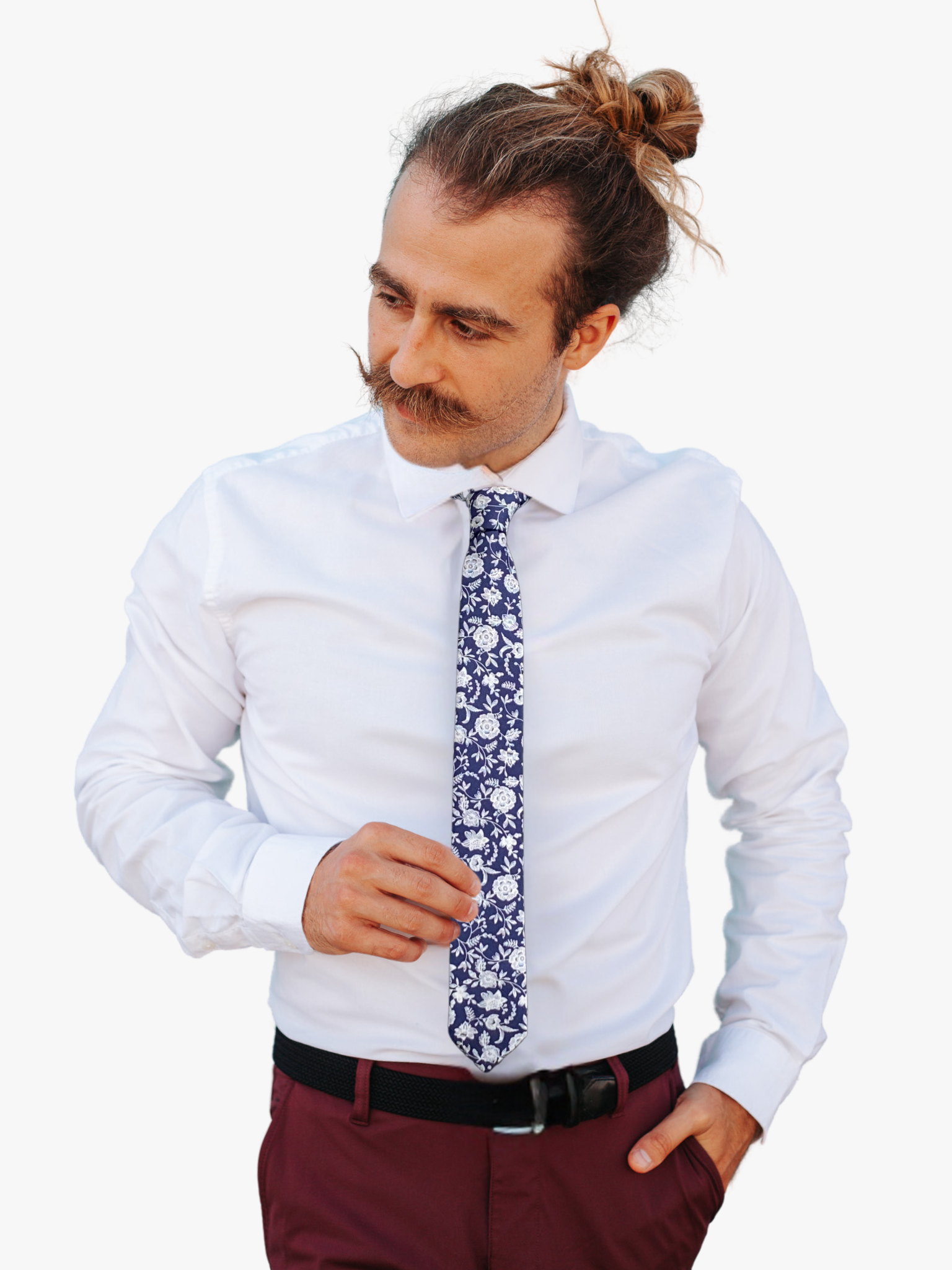 A man wearing a floral tie with navy blue fabric, and white flowers and vines remenisicent of fine china or talevera pottery.