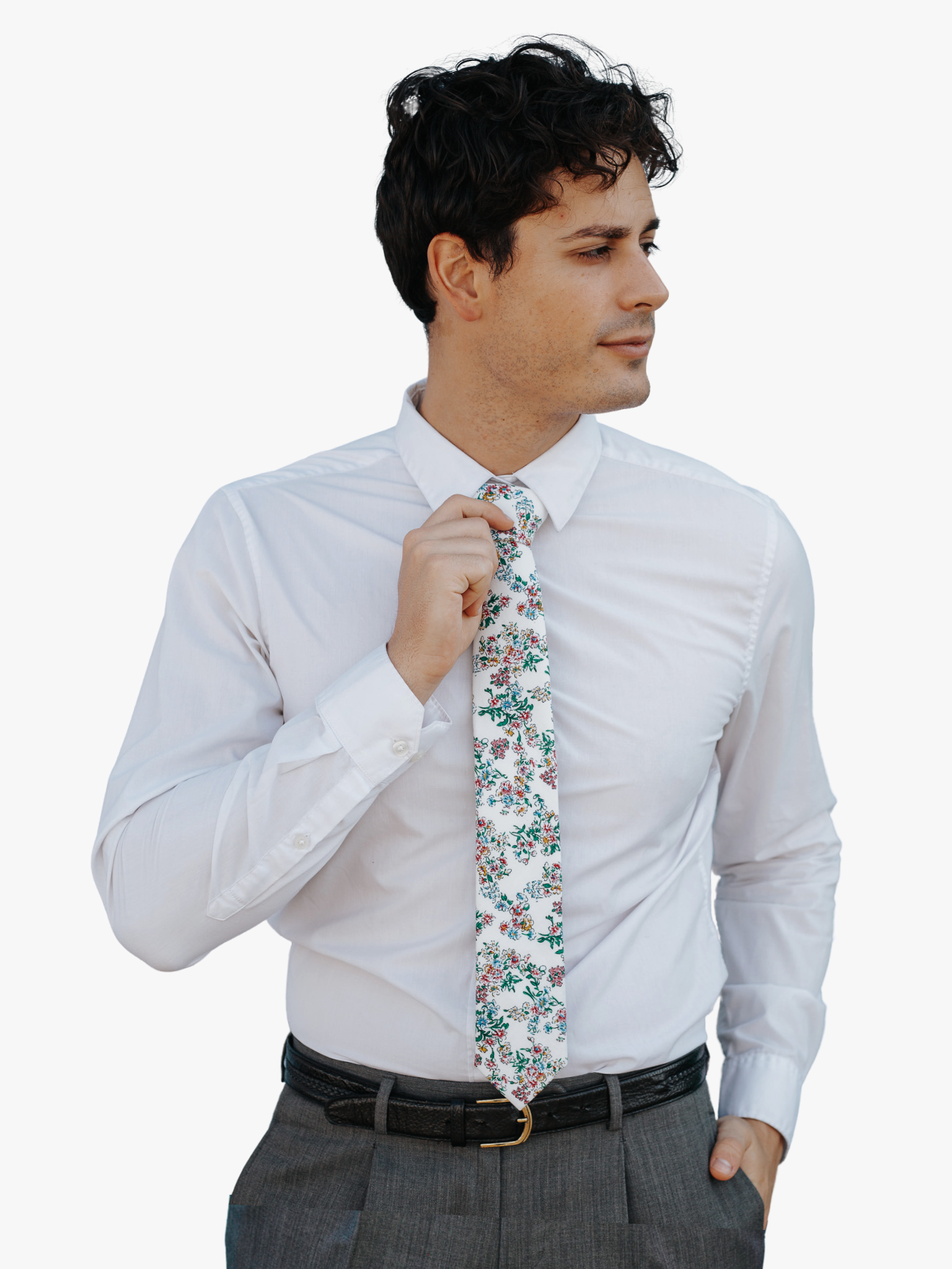 A man in dress clothes wearing a floral tie with watercolor turquoise flowers, pink and yellow blossoms, and green leaves.