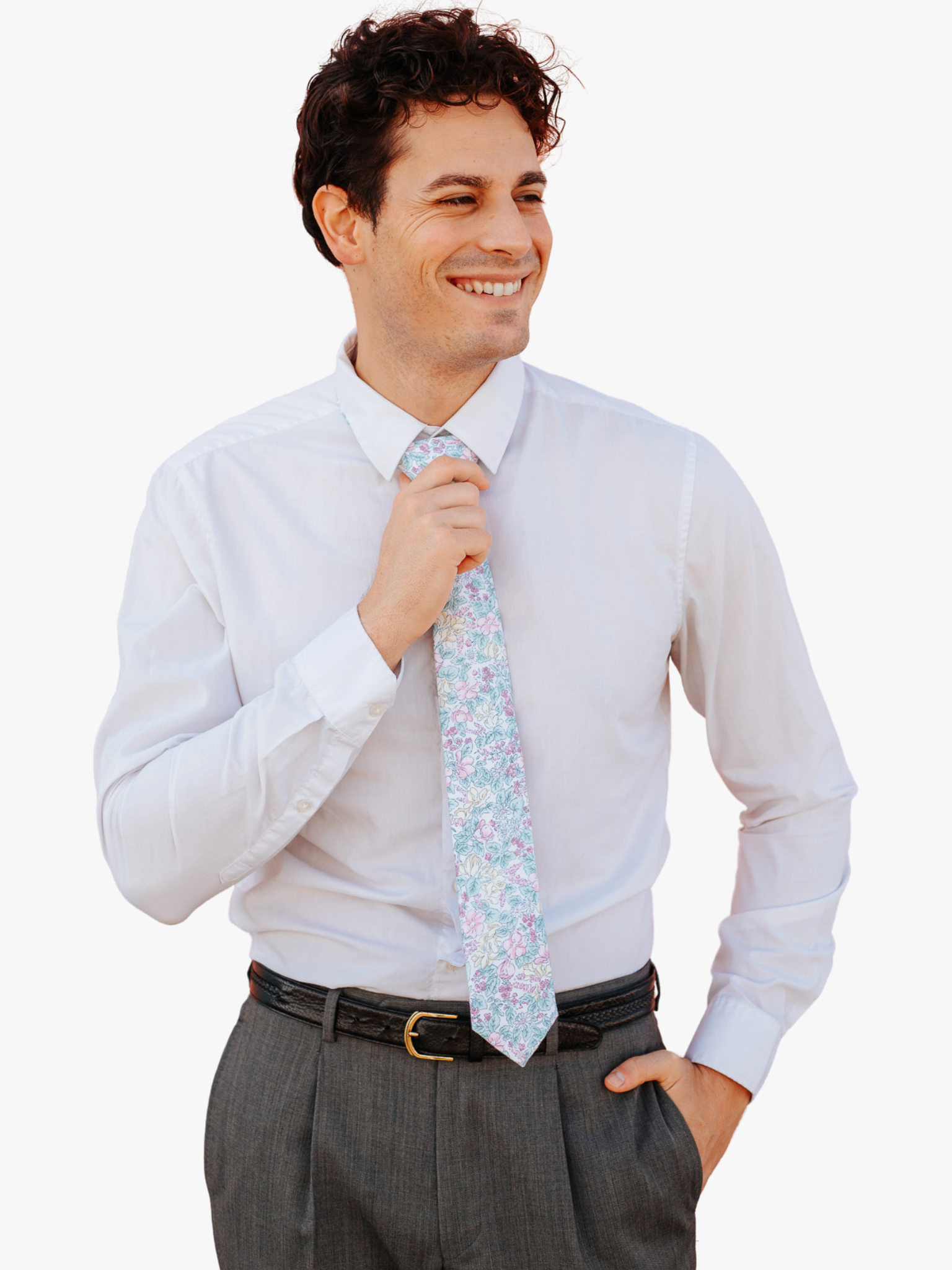 A man in dress clothes wearing a floral tie with pastel pink flowers, yellow petals, blossoms and light blue leaves.