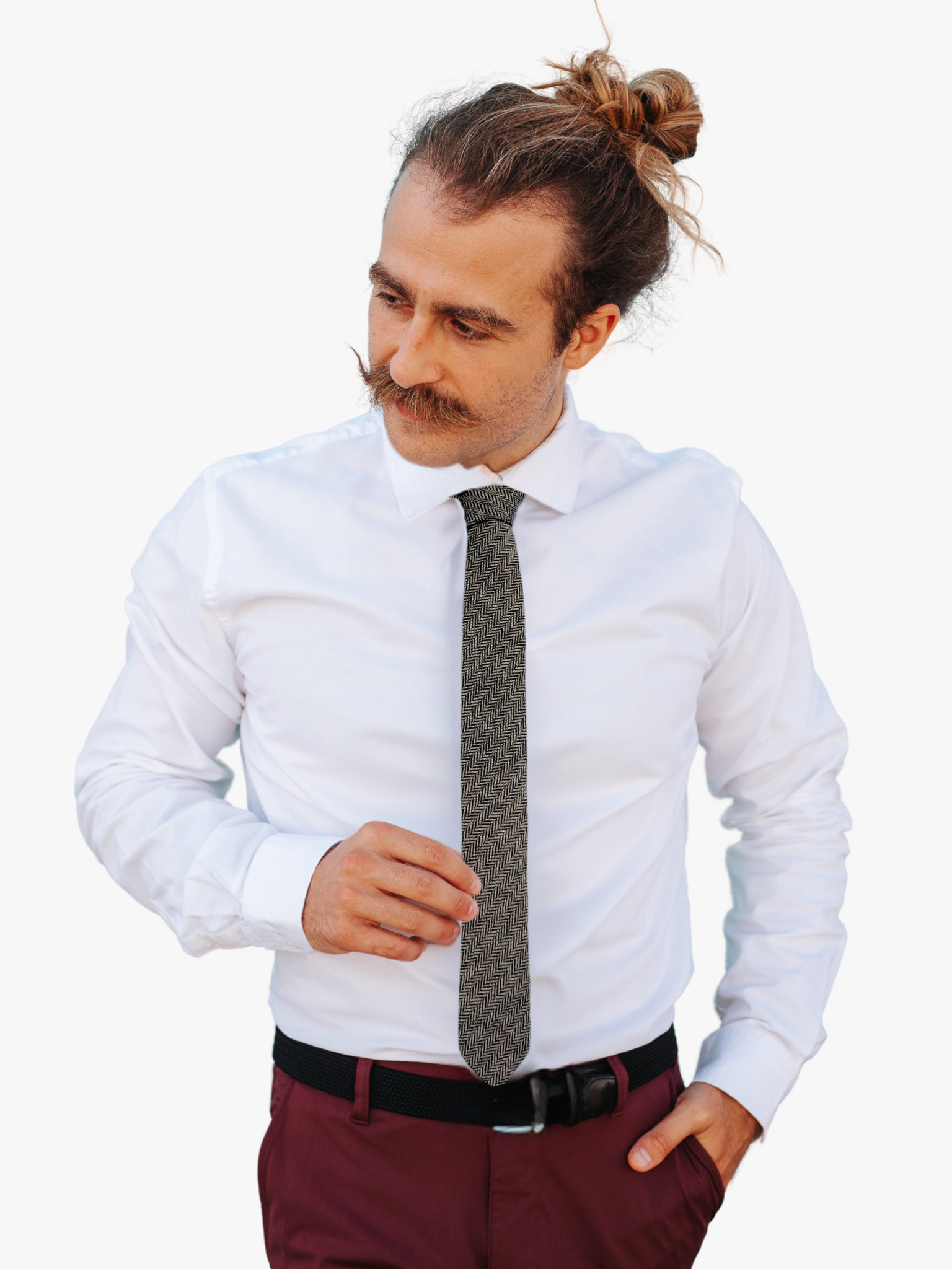 A man wearing a herringbone tie with alternating tan and black zigzag designs on a soft cotton fabric.