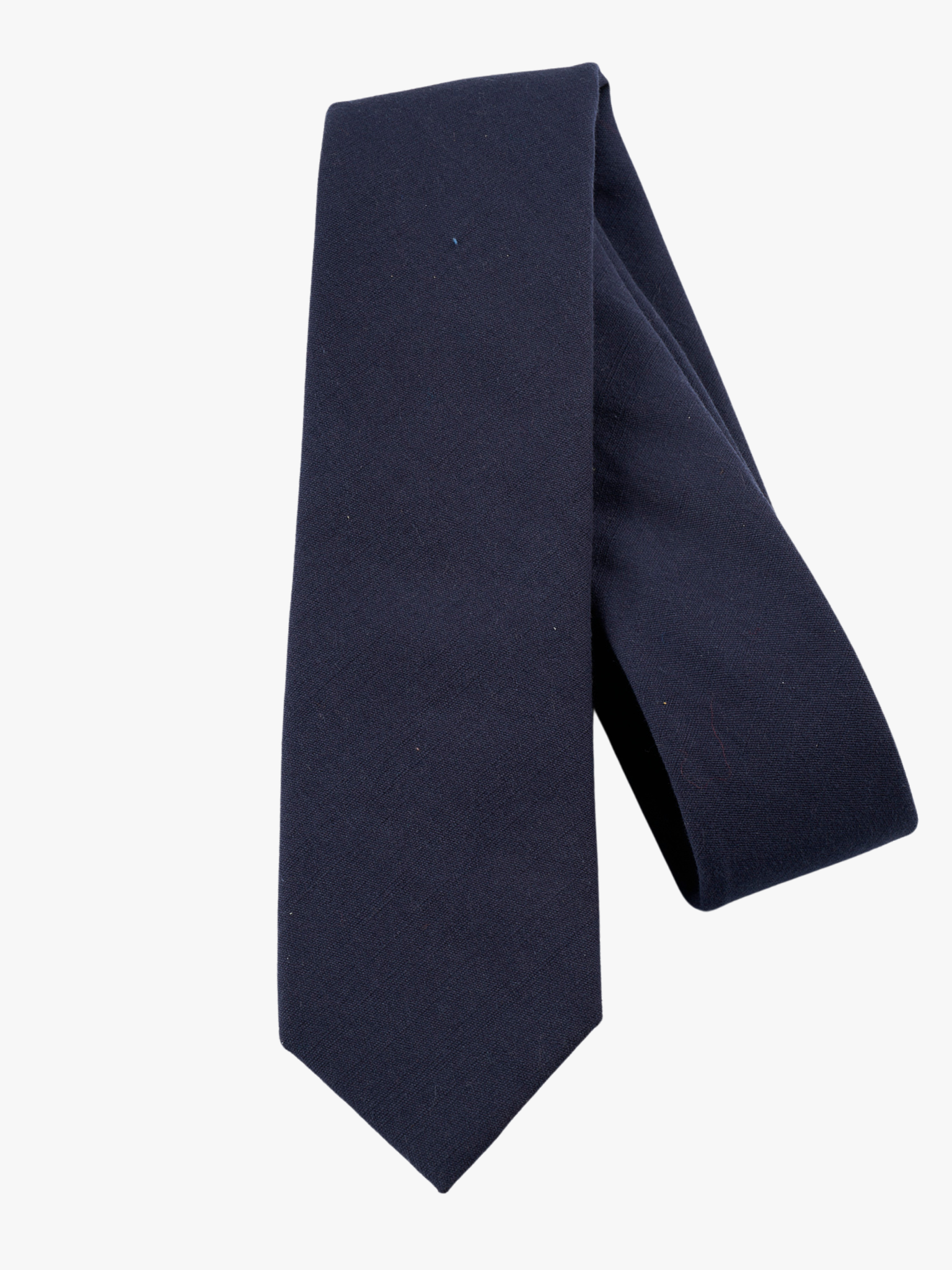 A folded solid woven cotton men's necktie with a simple navy blue color.