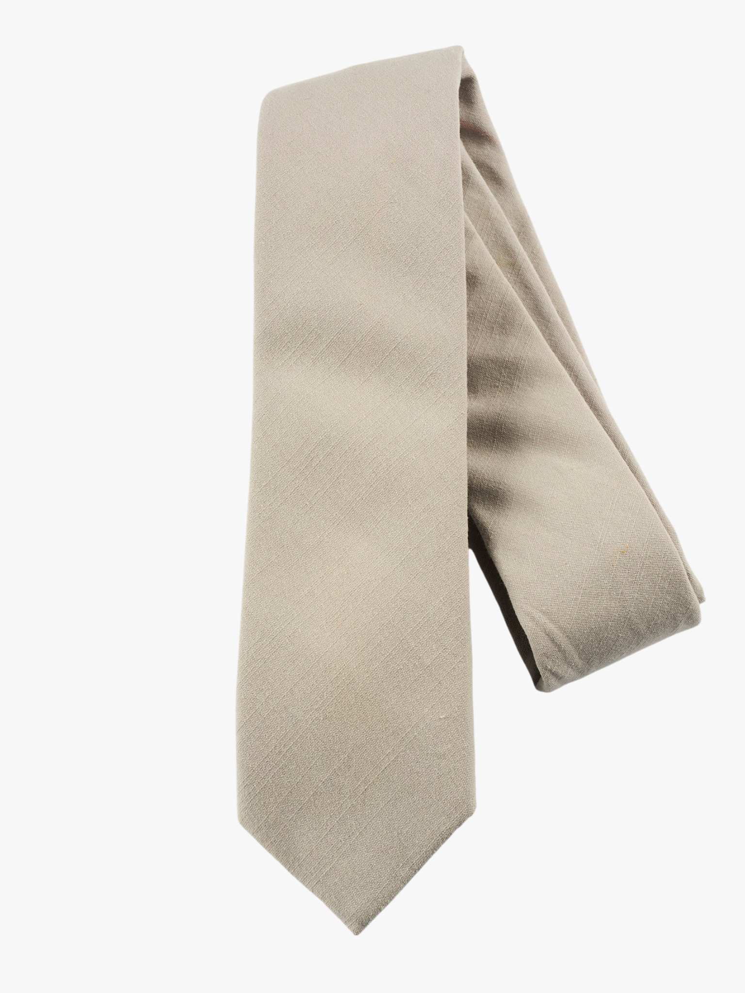 A folded solid pure cotton adult men's necktie with plain netural very light brown or sandy tan/gray  color.