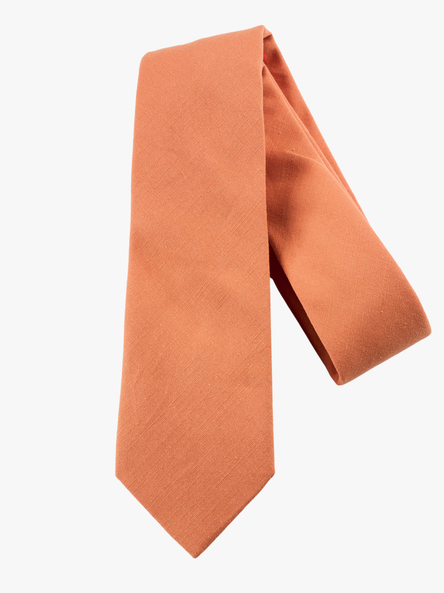 A folded solid woven cotton men's necktie with a simple burnt orange salmon color.