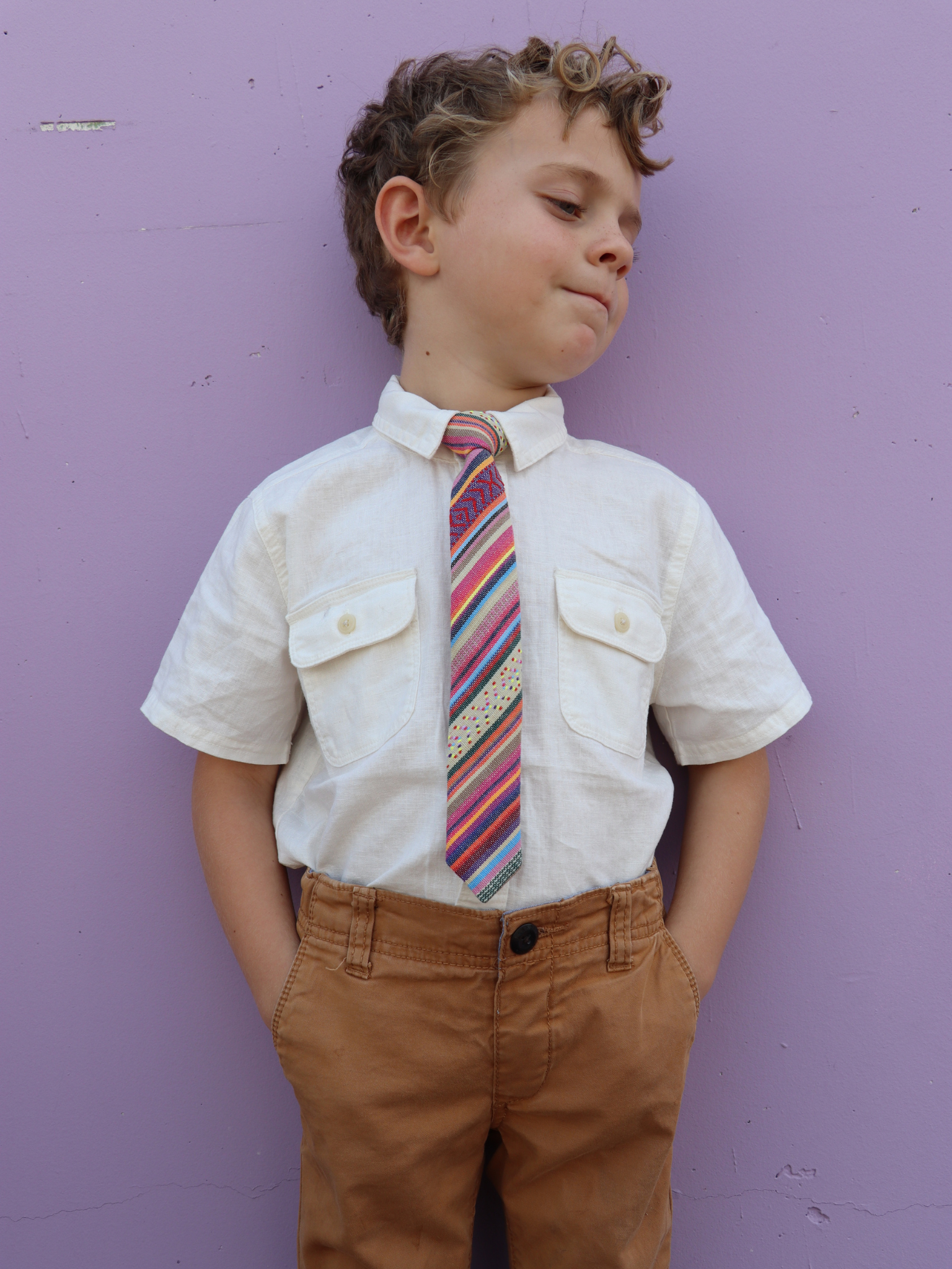 A boy in a white shirt with a blue and orange striped pre tied tie for kids ages 1-12 available in 4 childrens sizes.