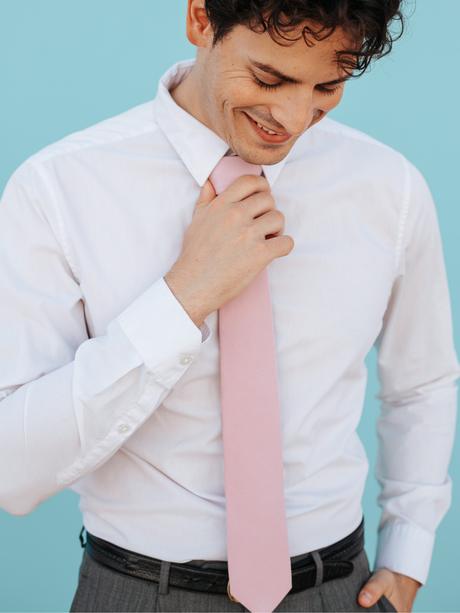 A close up of a man wearing a  light rose dusty pink solid-colored cotton skinny tie for weddings, grooms, and groomsmen.