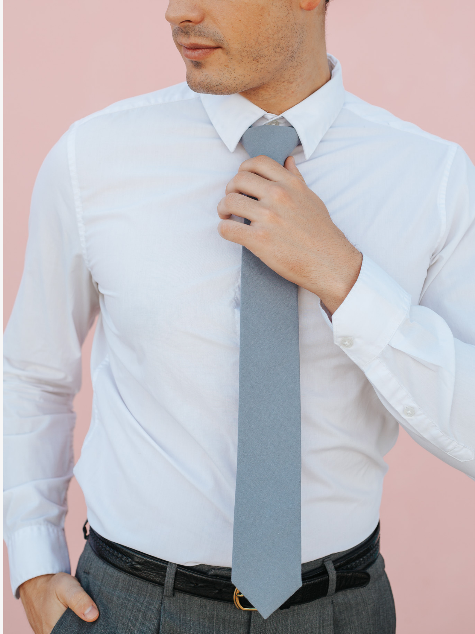 A close up of a man wearing a light gray-blue solid-colored cotton skinny tie for weddings, grooms, and groomsmen.