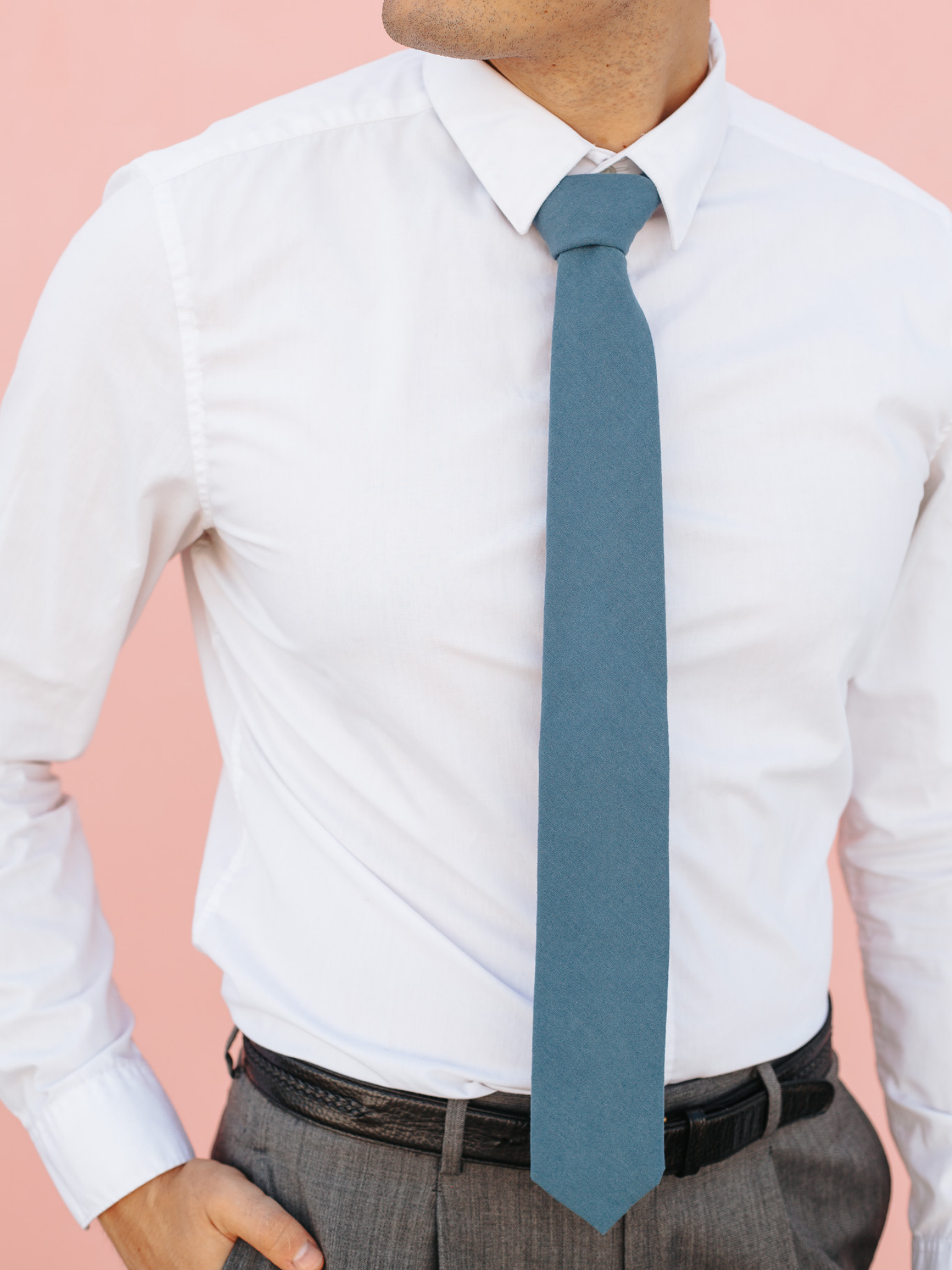 A close up of a man wearing a deep cobalt blue solid-colored cotton skinny tie for weddings, grooms, and groomsmen.