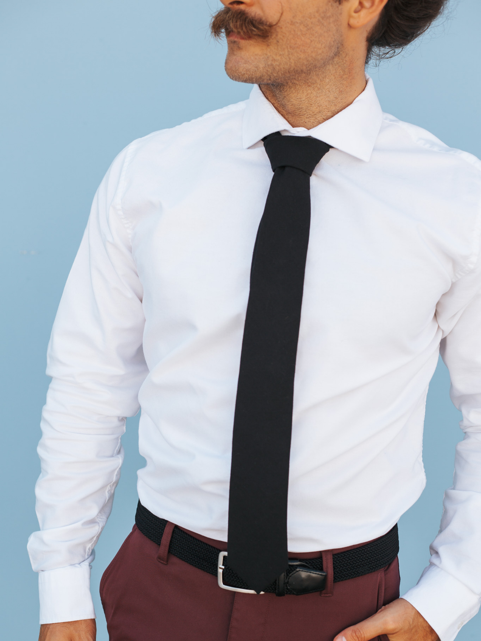 A close up of a man wearing a pitch black solid-colored cotton skinny tie for weddings, grooms, and groomsmen.