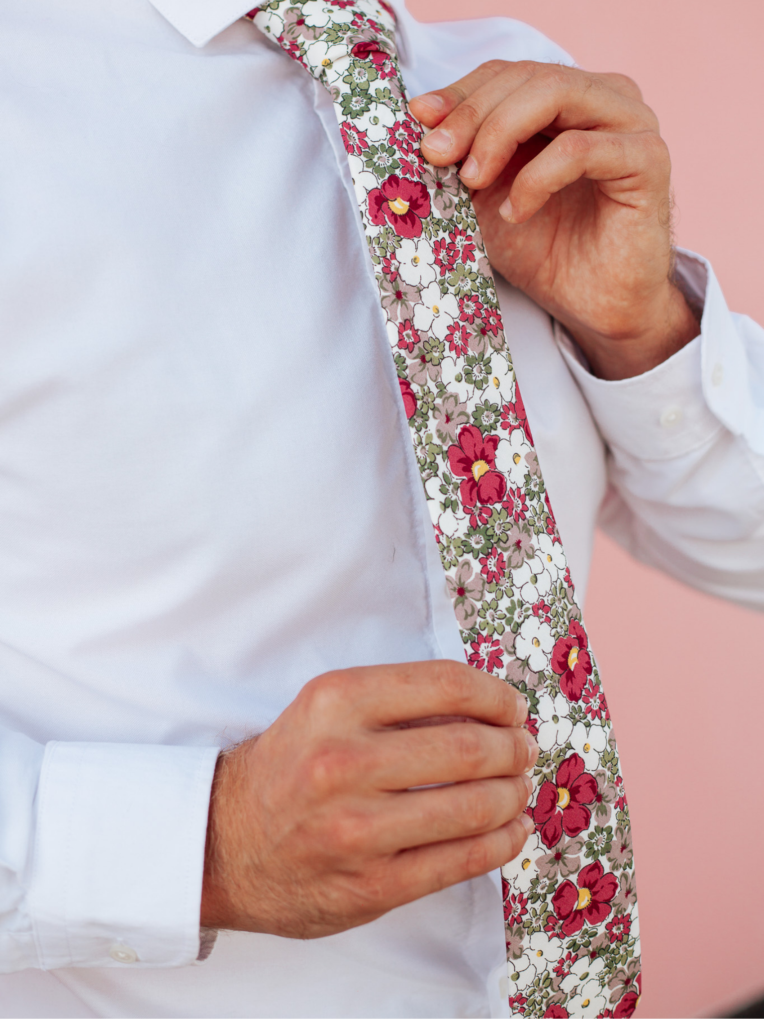 A close up of a man wearing a purple and white flower cotton skinny tie for weddings, grooms, and groomsmen.