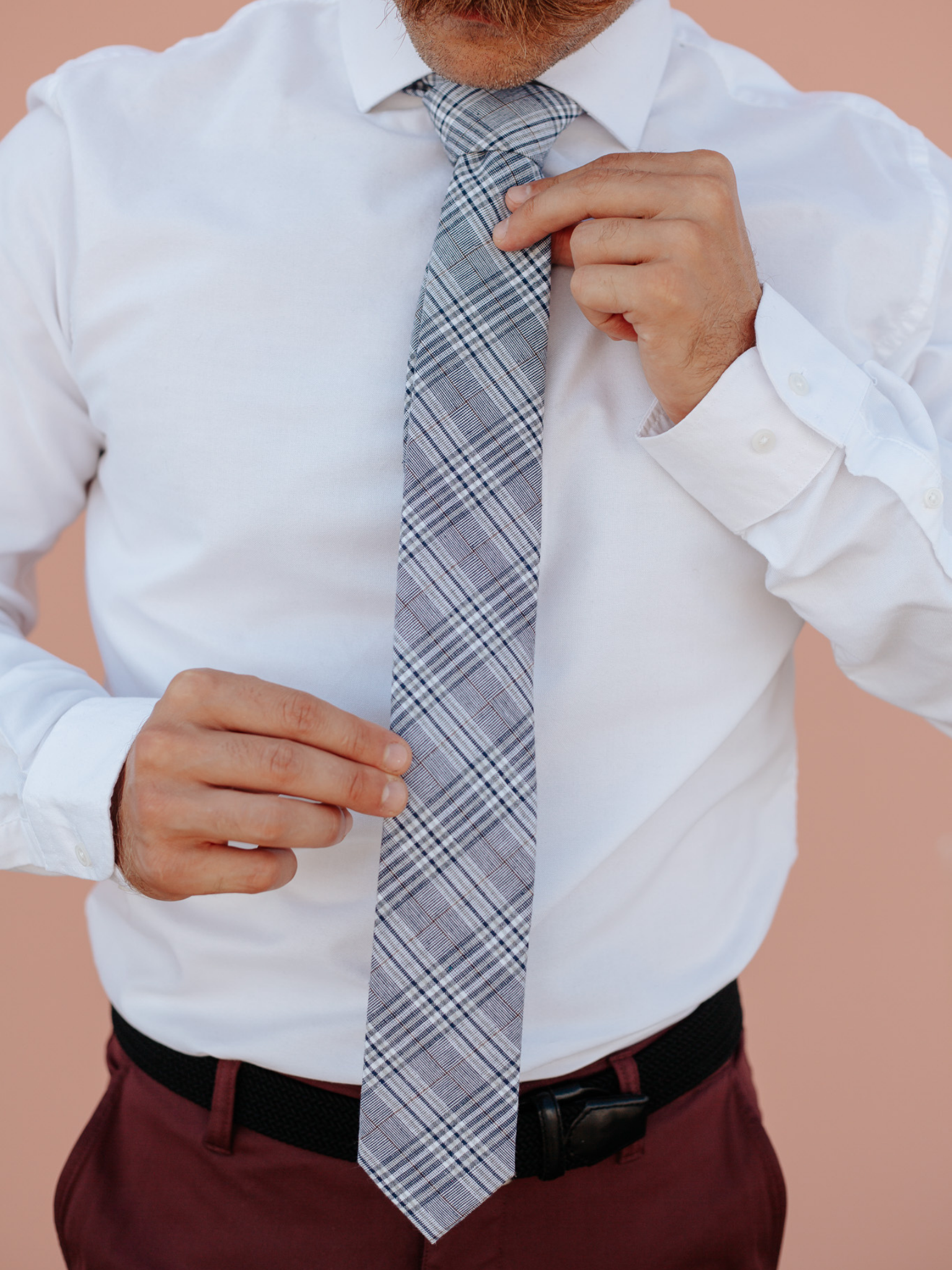 A close up of a man wearing a blue and white plaidcotton skinny tie for weddings, grooms, and groomsmen.