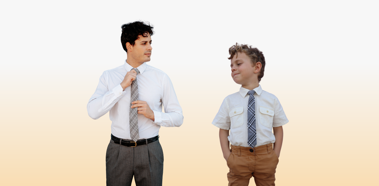 A man and child wearing matching black plaid ties in front of a faint orange background. 