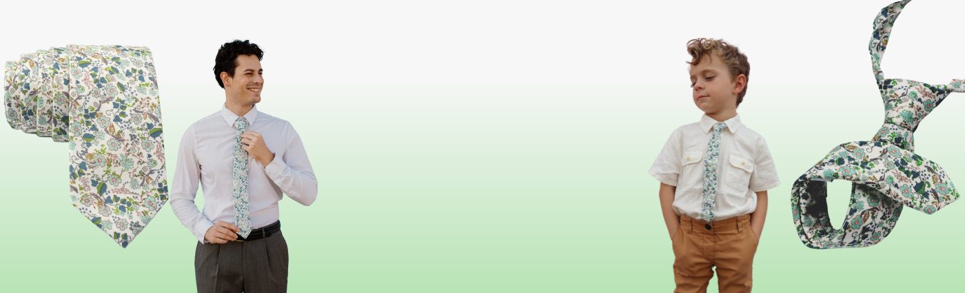 A man and boy in matching blue and green floral ties standing in front of a green background. 