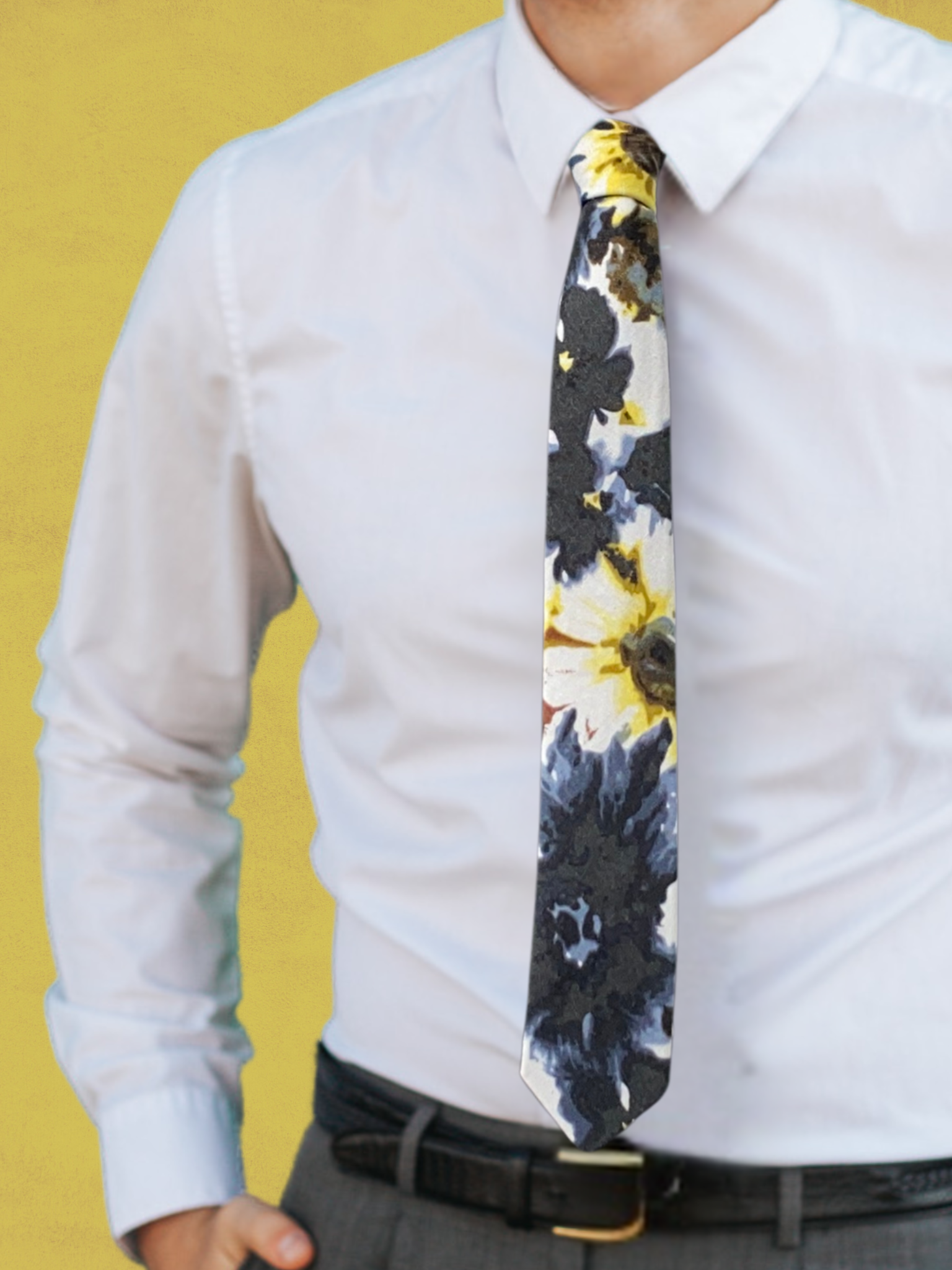 A close up of a man wearing a yellow, black, and blue flower cotton skinny tie for weddings, grooms, and groomsmen.