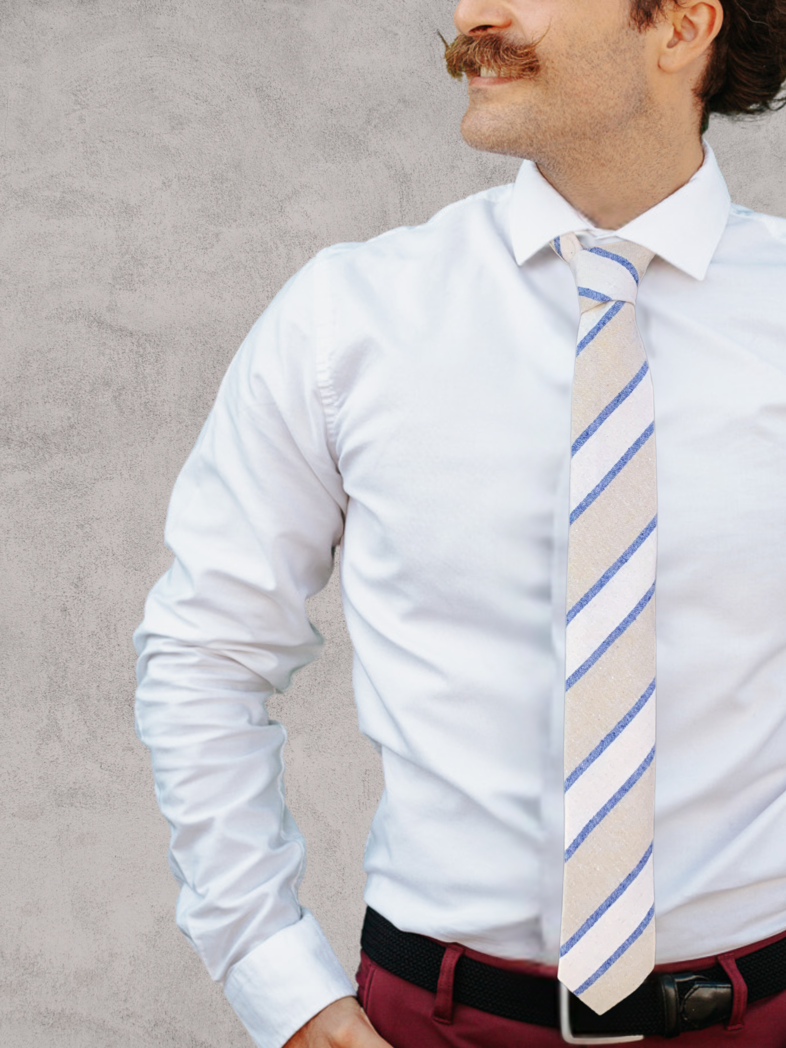 A close up of a man wearing a dark blue, beige, and light gray striped cotton tie for weddings, grooms, and groomsmen.
