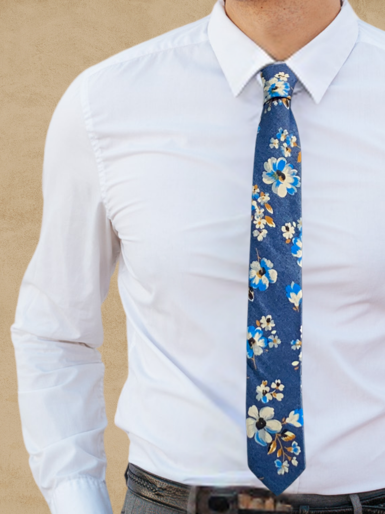 A close up of a man wearing a blue, white, and bronze flower cotton skinny tie for weddings, grooms, and groomsmen.
