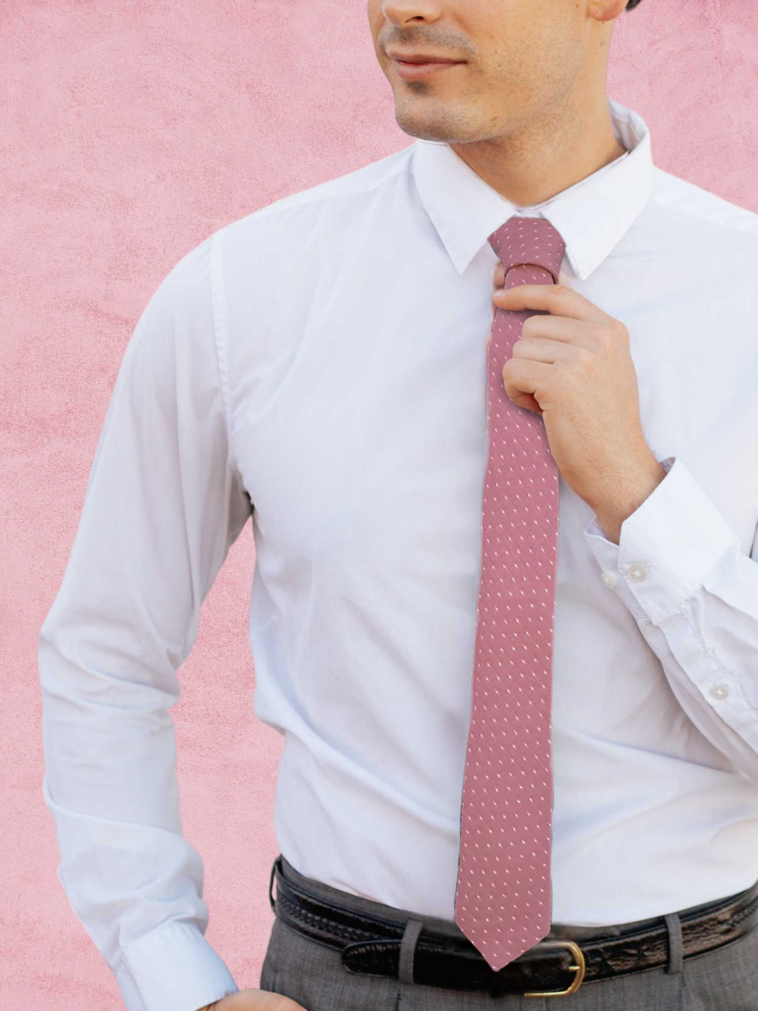 A close up of a man wearing a dark fuchsia pink and white polka dot cotton tie for weddings, grooms, and groomsmen.