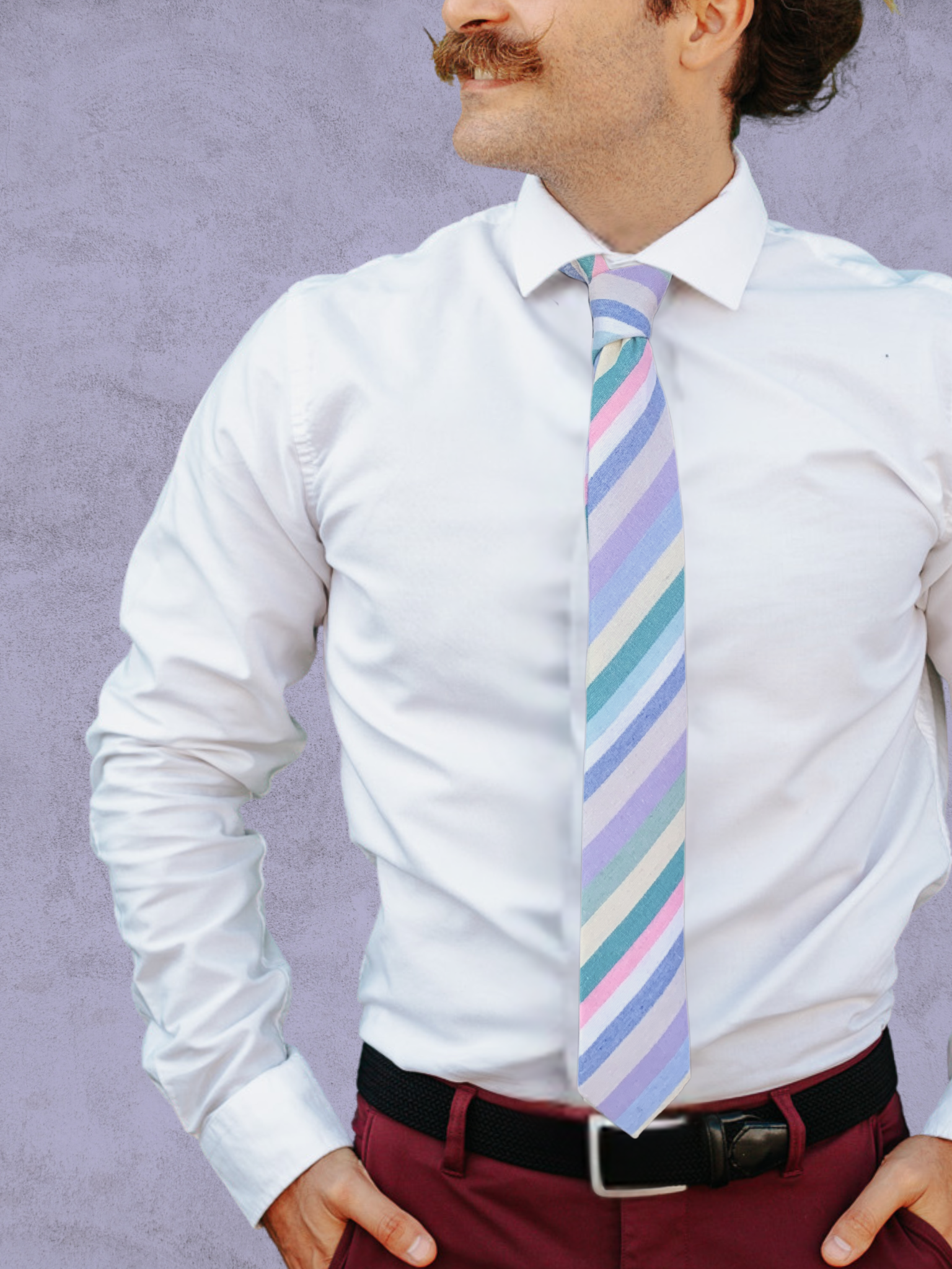 A close up of a man wearing a pastel pink, lavender, white, and green striped cotton tie for weddings, grooms, and groomsmen.