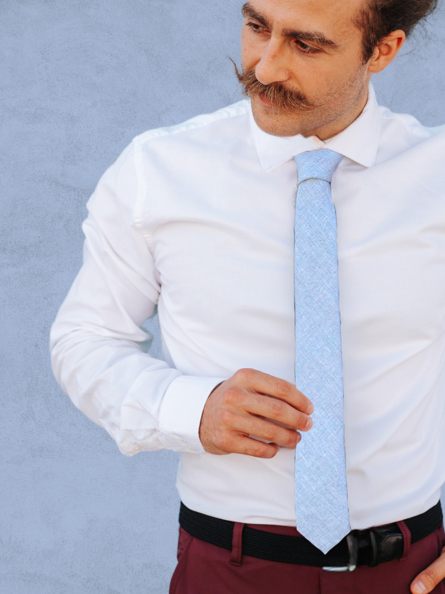 A close up of a man wearing a light stone gray solid speckled cotton tie for weddings, grooms, and groomsmen.