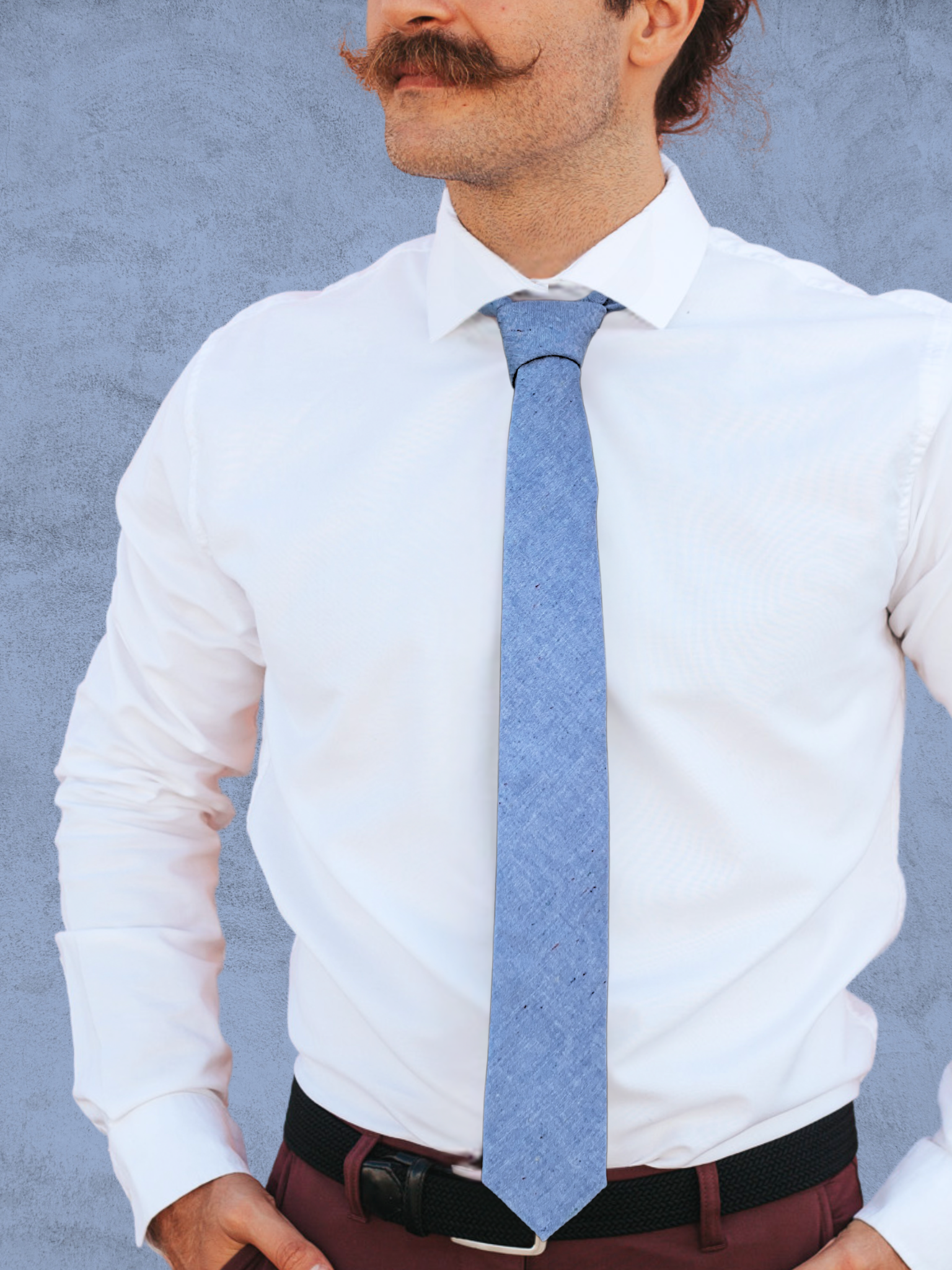 A close up of a man wearing a pale baby blue solid speckled cotton tie for weddings, grooms, and groomsmen.
