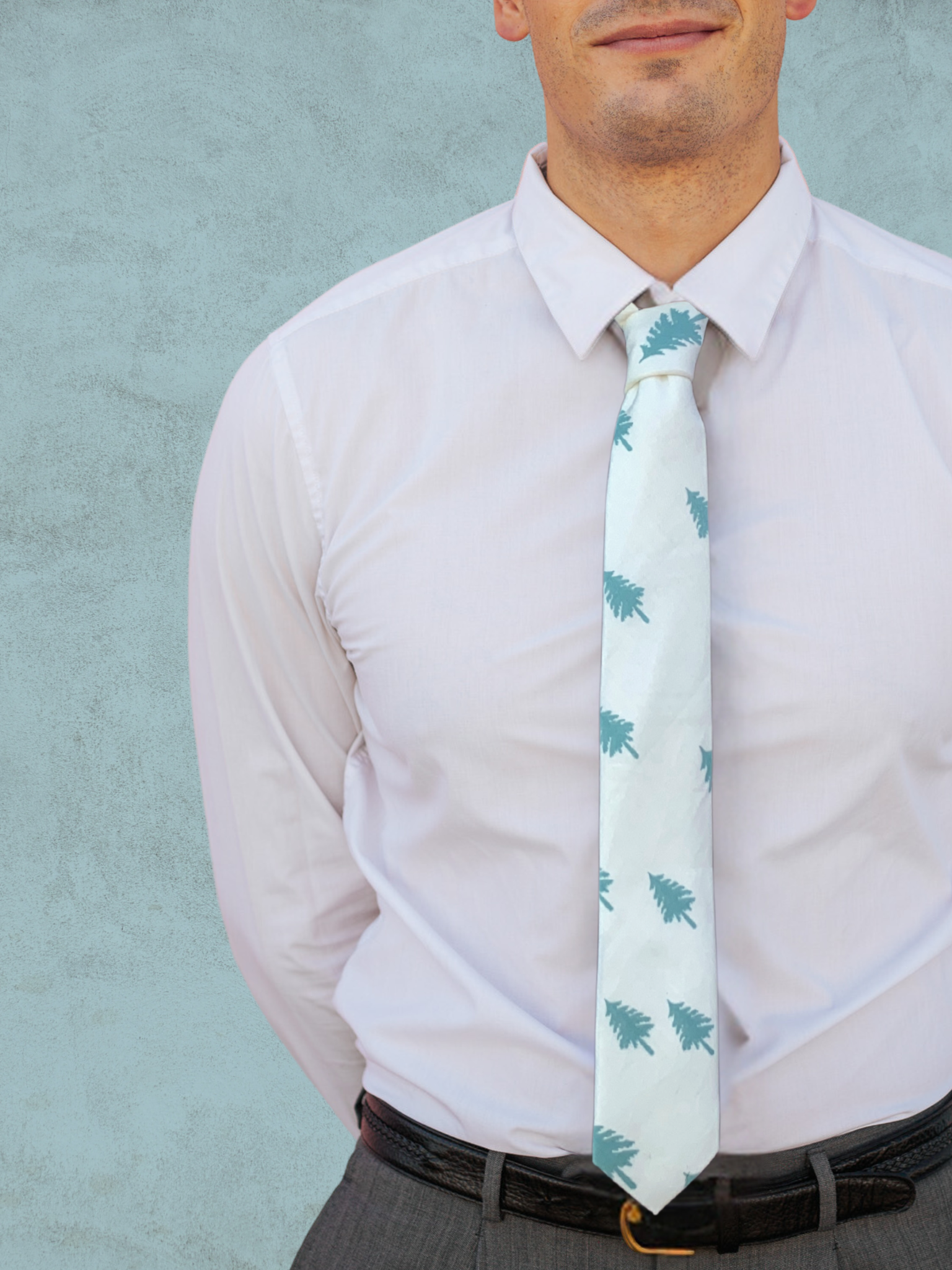 A close up of a man wearing a pale jade green and snowy white Christmas tree cotton tie for parties, church, and work.
