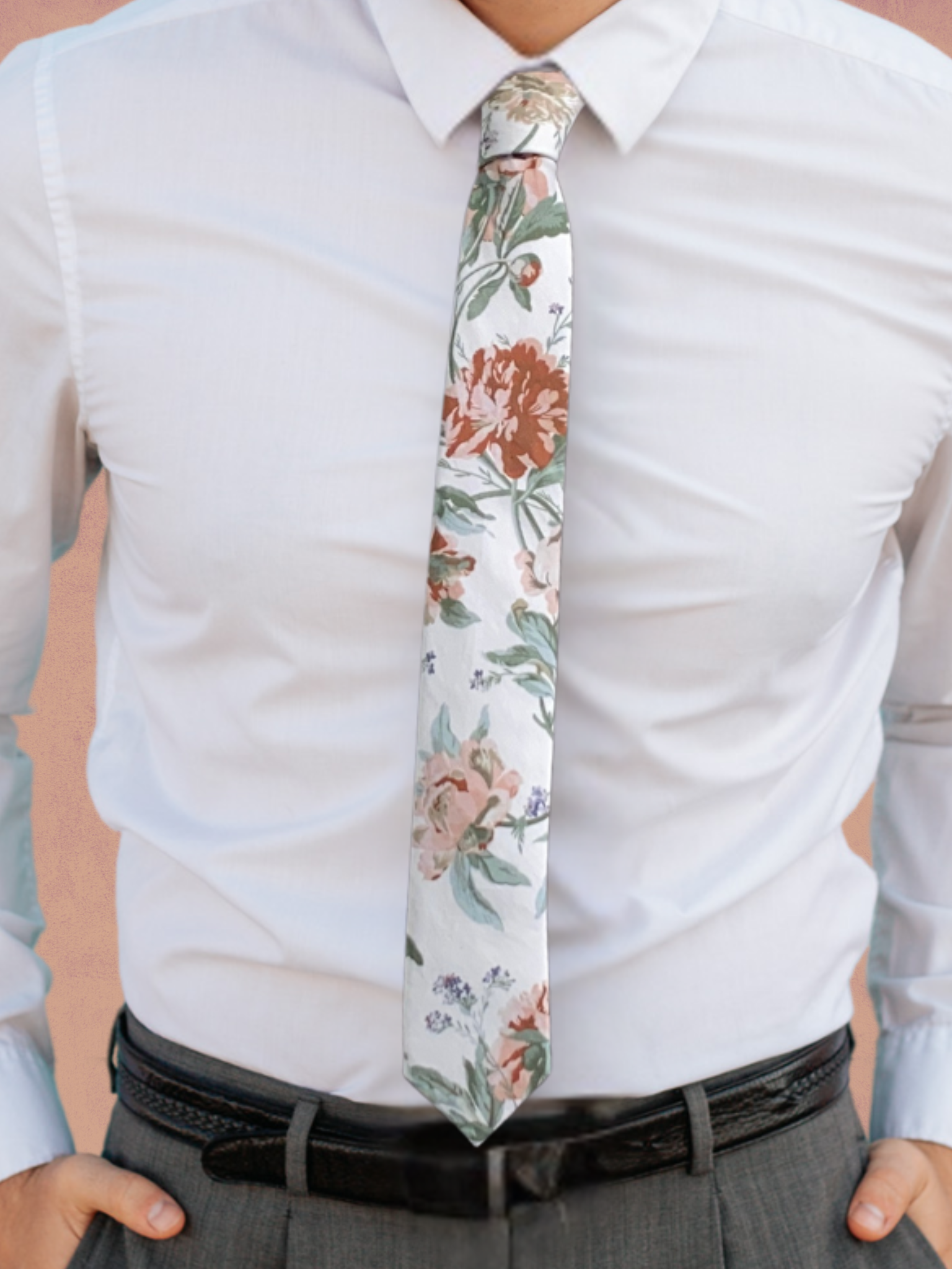 A close up of a man wearing a white, pale pink, and pastel light green flower cotton tie for weddings grooms and groomsmen.